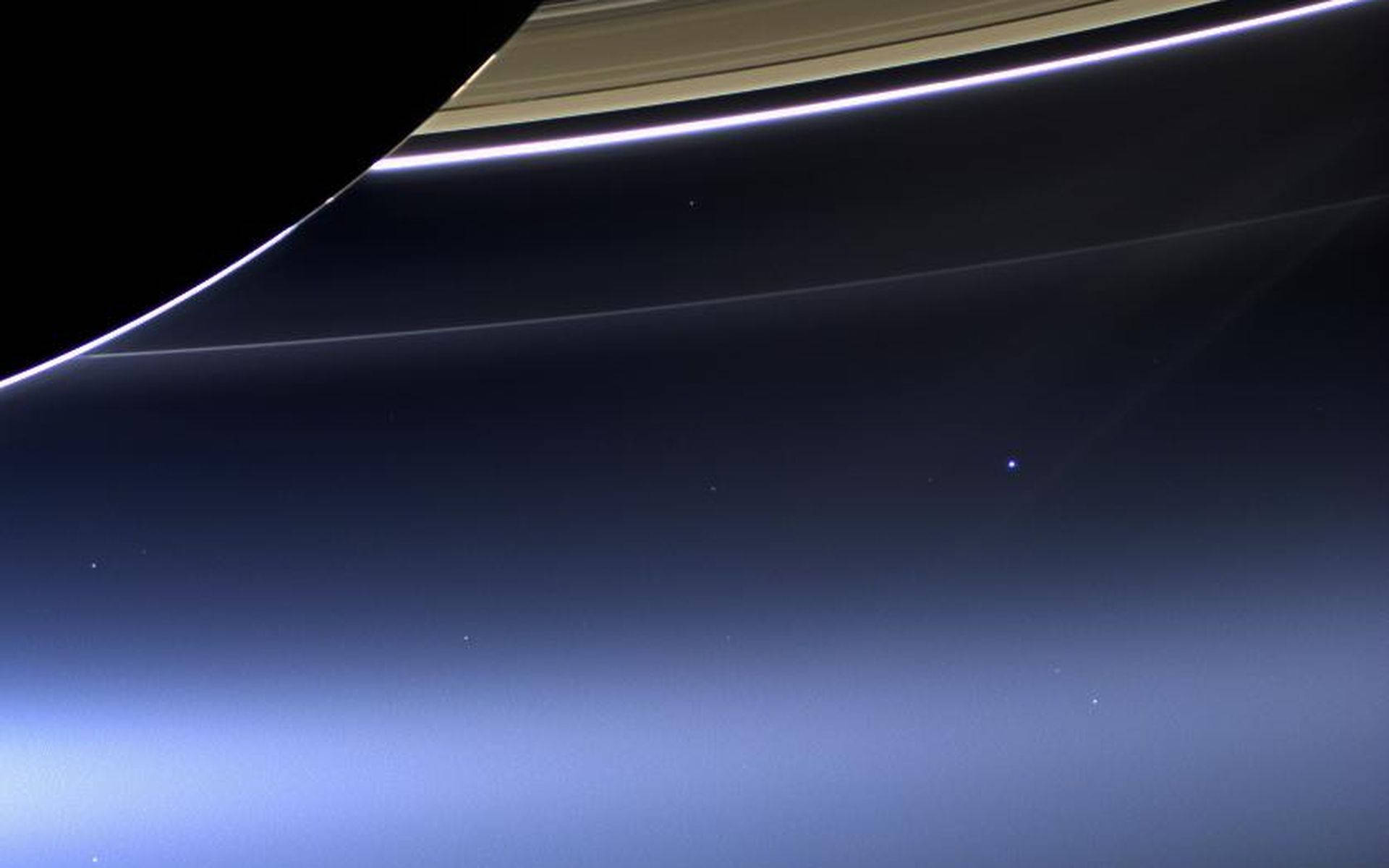 土星的標誌性環在太空中穿過深藍色大氣漸變彎曲。
