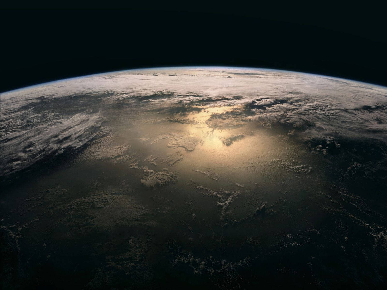 從太空觀看行星地球，陽光照射彎曲地平線上的雲層。