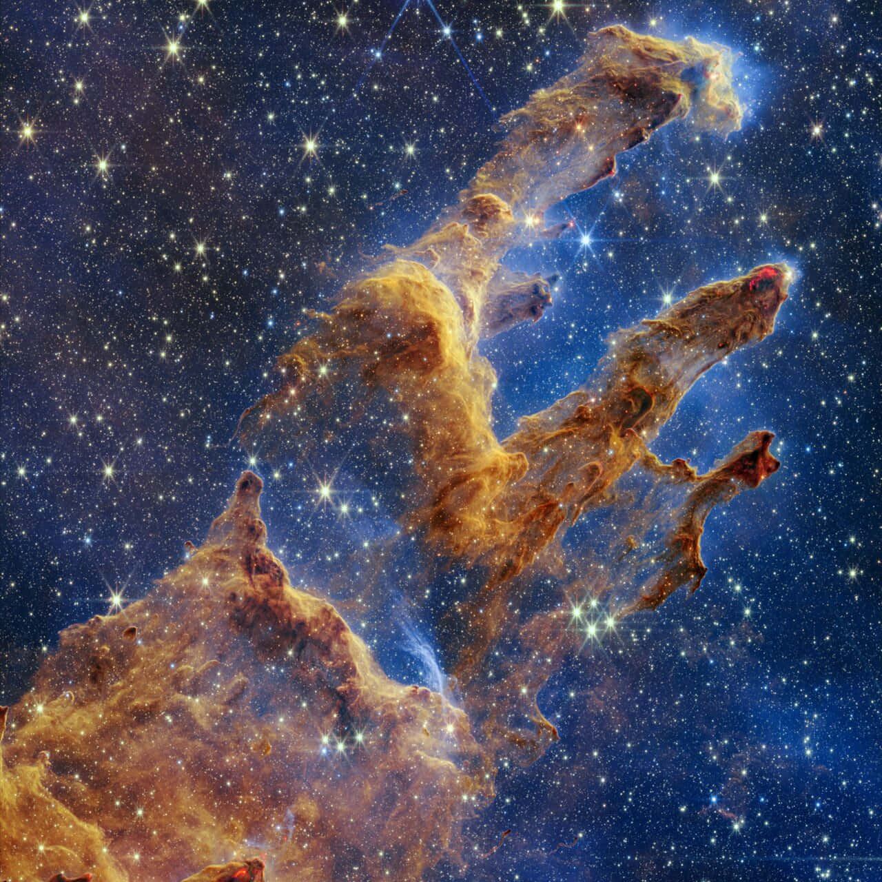 NASA拍攝的創生之柱 壁紙 — 在鷹星雲中，一道宏偉的宇宙氣體和塵埃柱，在星場背景下發出琥珀色和藍色光芒。