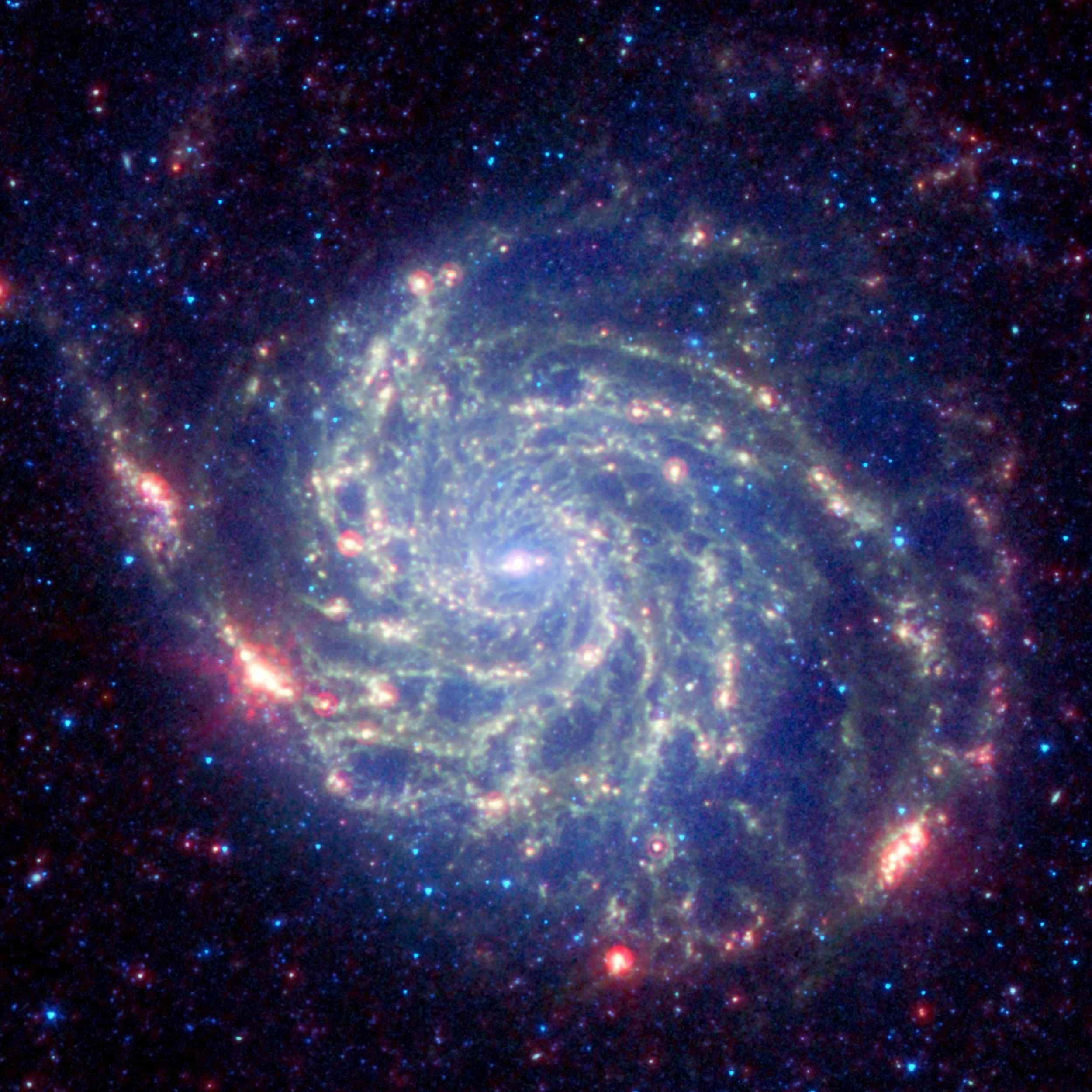 NASA揭示的宇宙浩瀚之美 壁紙 — 一個令人驚嘆的螺旋星系，在黑暗的宇宙背景下旋轉著發光的藍色和紅色恆星。