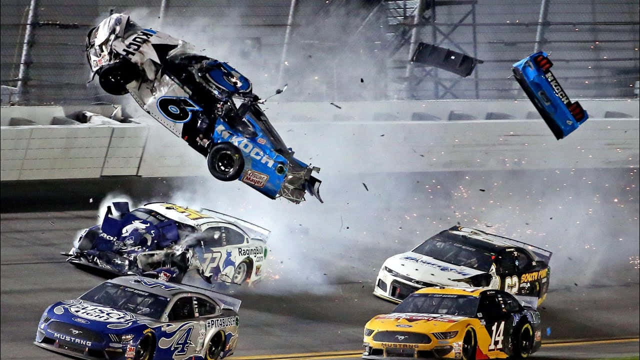 NASCAR賽事的興奮感 壁紙 — 夜間高速NASCAR撞車事故，賽車在賽道上翻滾並冒煙。
