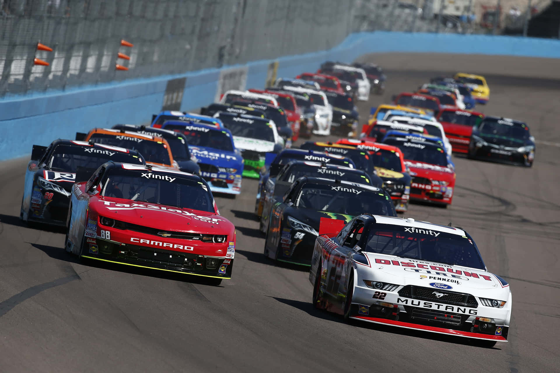 NASCAR賽車在日落時分於賽道上飛馳。