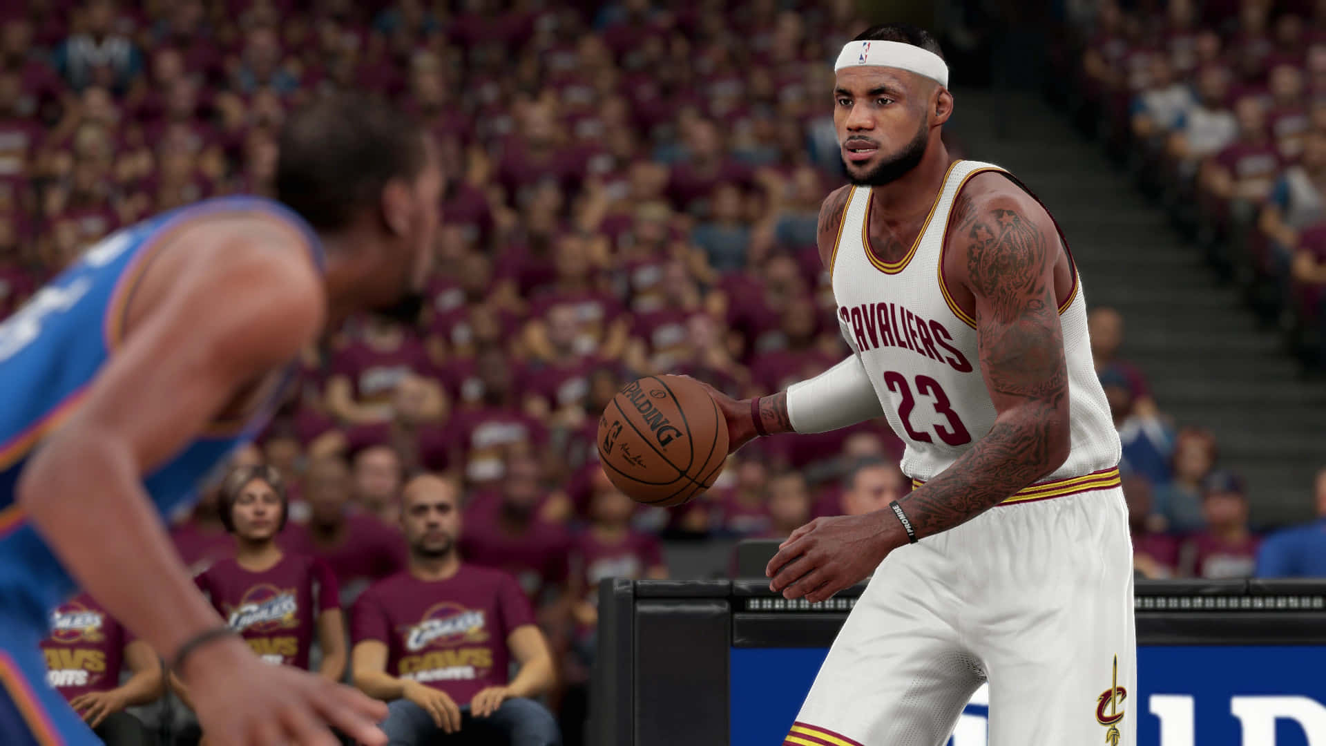 NBA 2K 賽中勒布朗·詹姆斯持球瞬間 壁紙 — 一名身穿白色騎士隊球衣的籃球運動員在擠滿觀眾的場館中運球，與對手對峙。