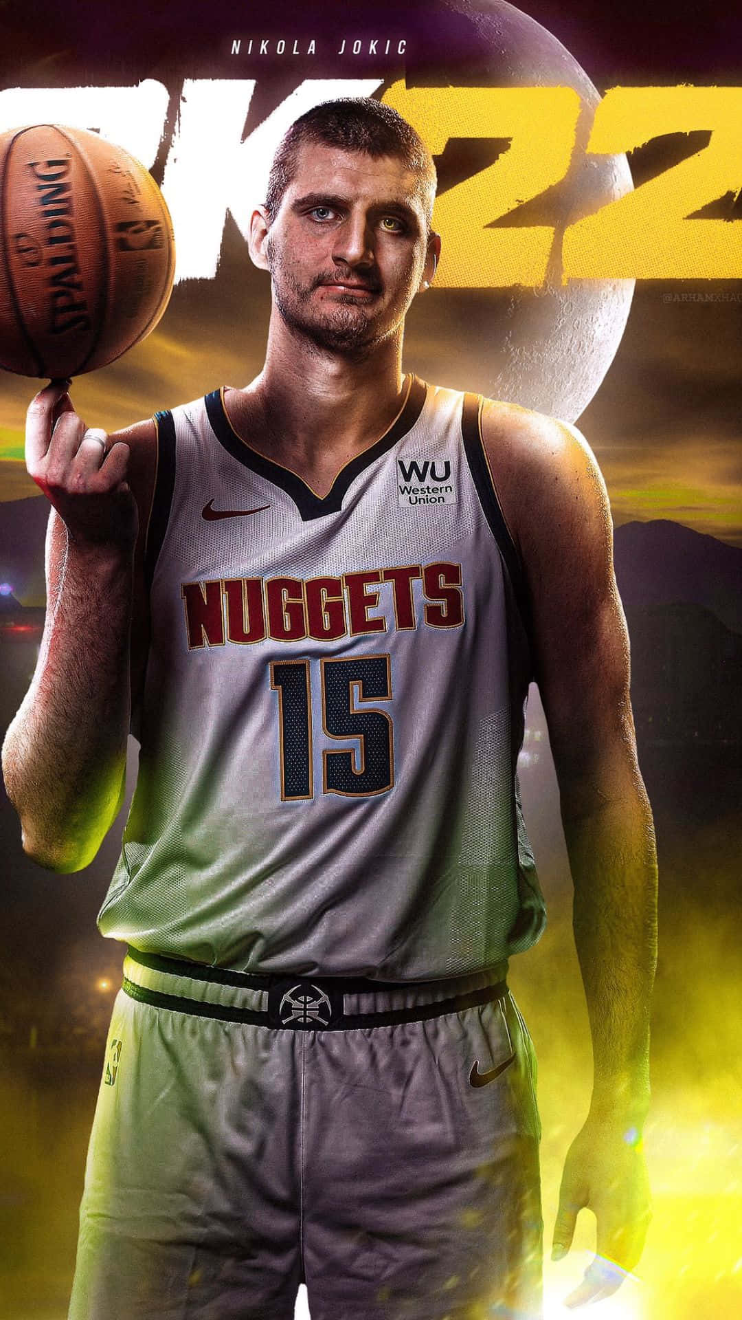塞爾維亞籃球選手尼古拉·約基奇 NBA 2K22 壁紙 — 身穿丹佛金塊球衣的尼古拉·約基奇在發光的黃色和紫色宇宙背景前手持籃球，並帶有'Nikola Jokic 22'文字。