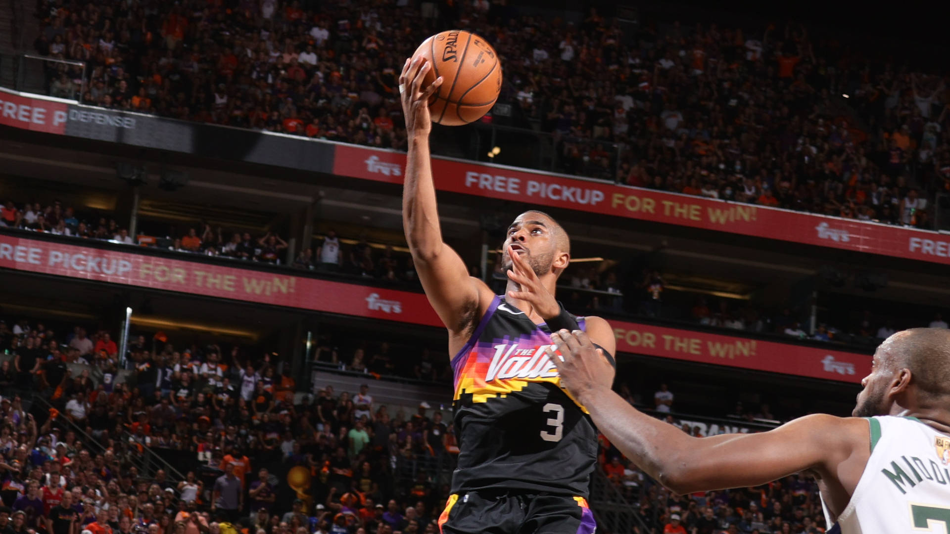 NBA總決賽太陽隊克里斯·保羅 壁紙 — 一名身穿黑色和紫色Suns球衣的籃球運動員跳起投籃，而一名身穿白色球衣的防守球員伸手阻擋。
