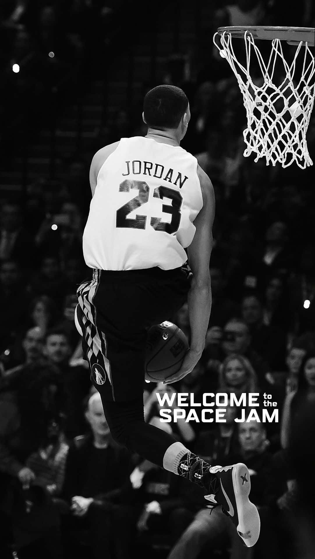 「讓您感覺身處NBA賽季之中！」 壁紙 — 一張黑白照片，一名身穿Jordan 23球衣的籃球運動員在半空中向籃框灌籃，並帶有'WELCOME to the SPACE JAM'文字。