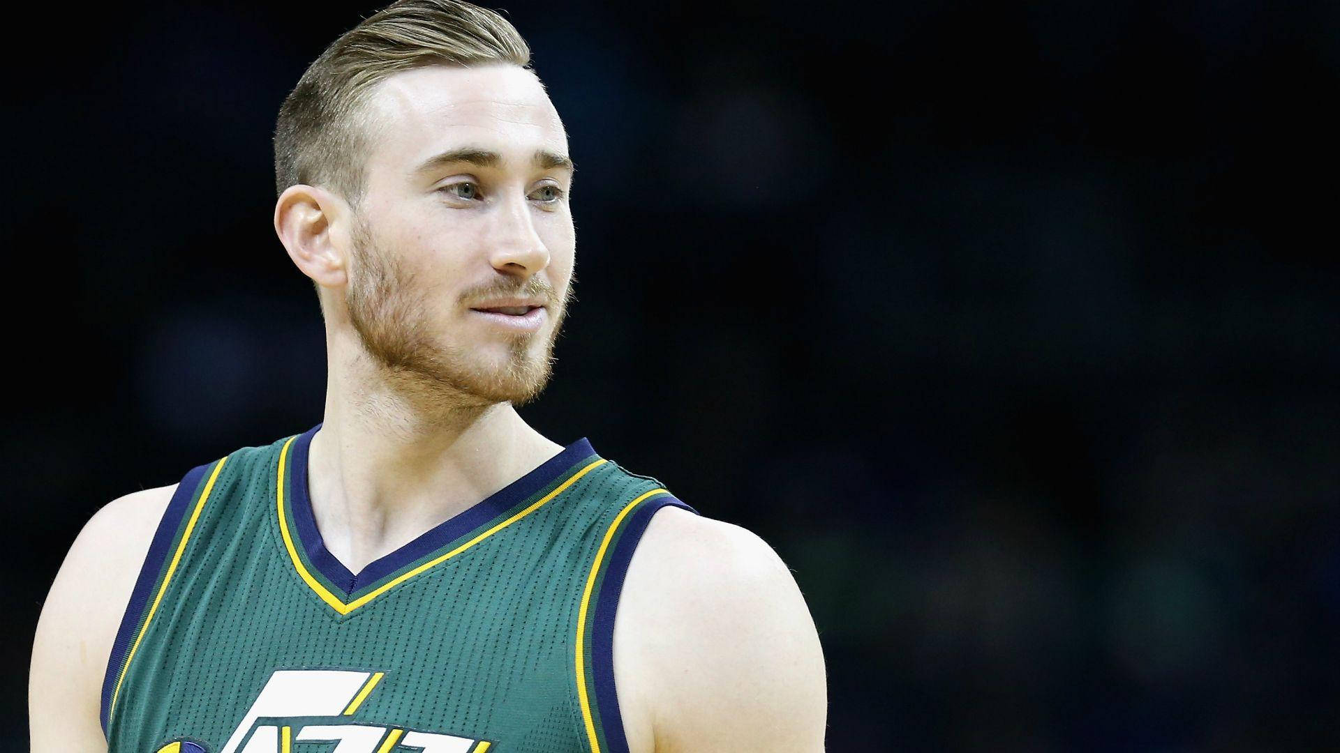 戈登·海沃德NBA爵士隊近照 壁紙 — 近距離肖像，一名留鬍鬚的籃球運動員身穿綠色和黃色球衣，背景為深色模糊。