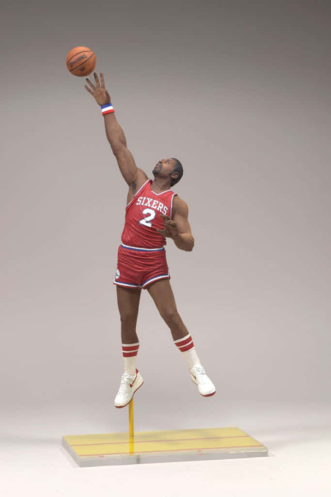 NBA運動員摩西·馬龍人偶 壁紙 — 一個身穿紅色Sixers球衣的籃球運動員精細人偶，在半空中投籃，背景為純灰色。