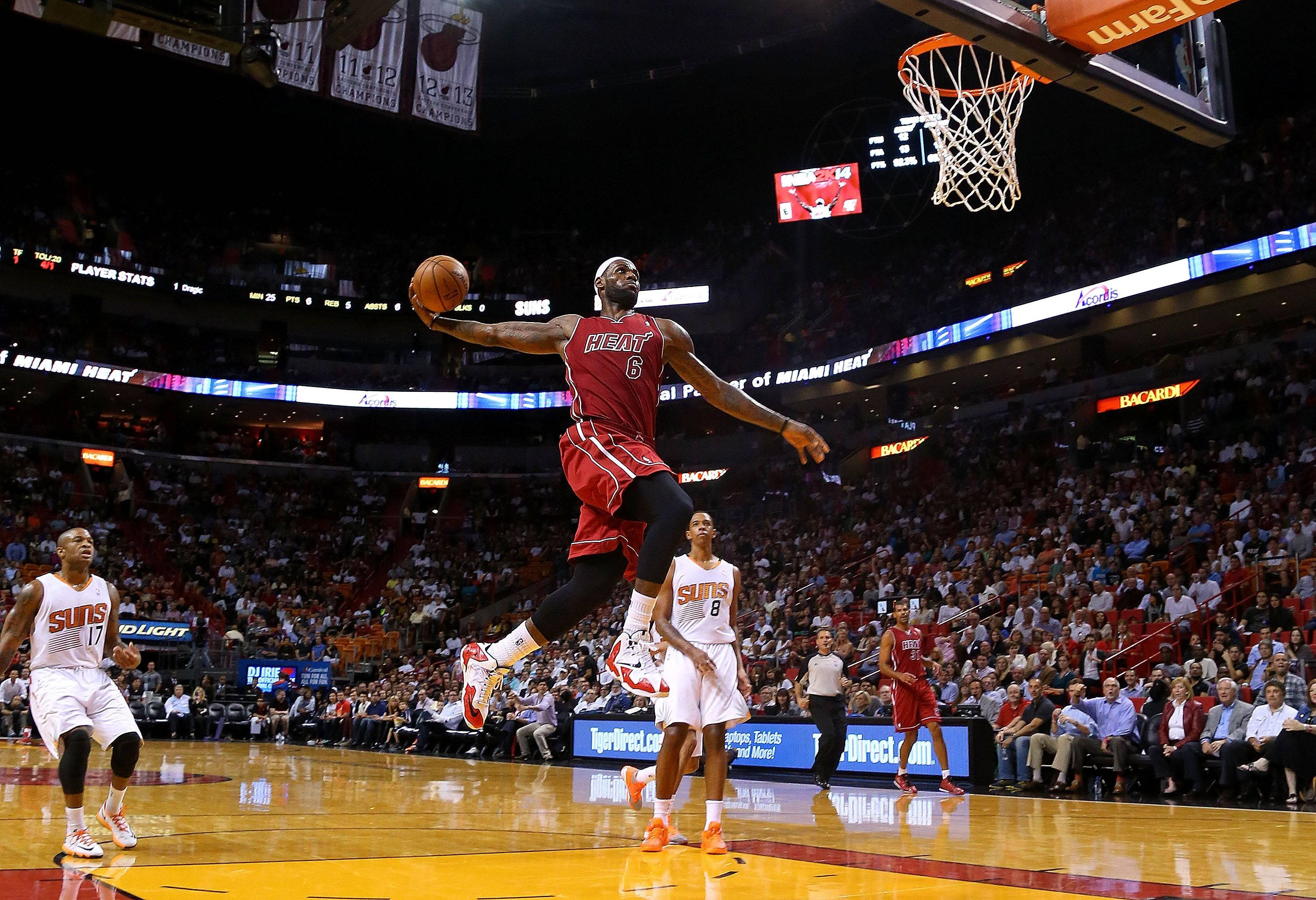 勒布朗·詹姆斯在NBA比賽中強力灌籃 壁紙 — 一名邁阿密熱火球員在明亮的場館燈光下，於一場座無虛席的NBA比賽中高高躍起灌籃。