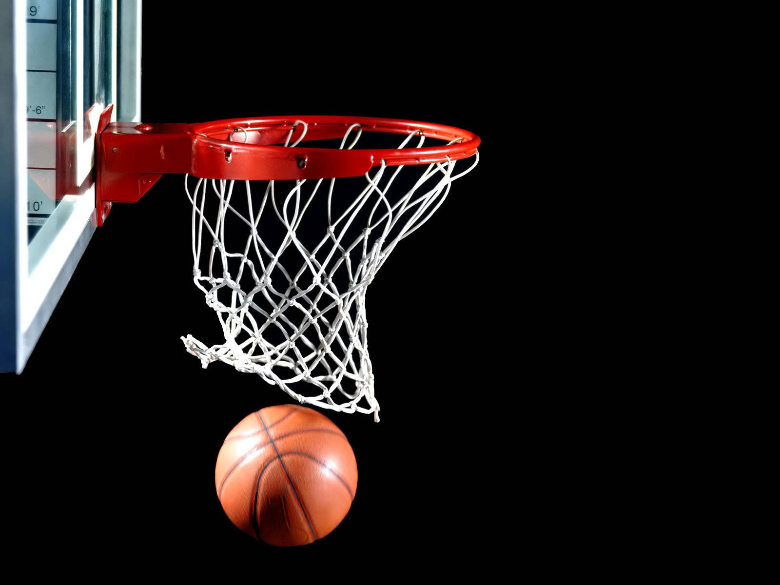 酷炫NBA戒指特寫 壁紙 — 一個籃球在半空中被捕捉，即將穿過一個紅色籃框，背景為純黑色。