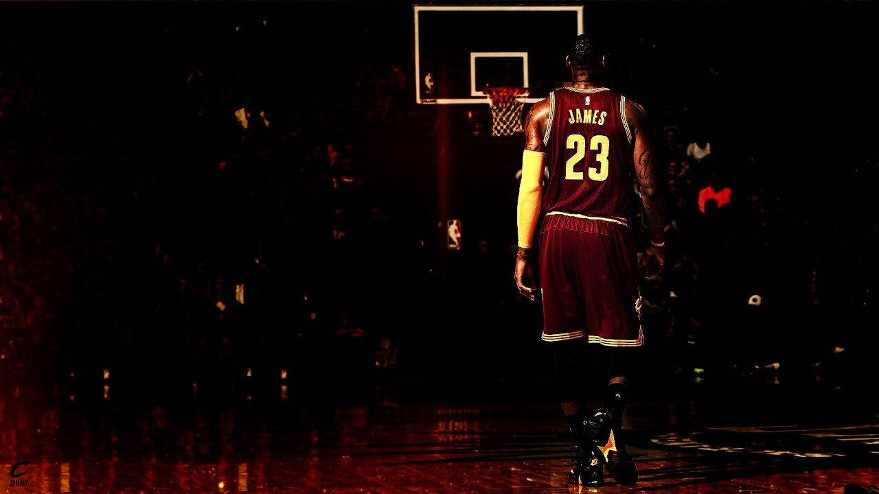 NBA巨星勒布朗·詹姆斯 壁紙 — 一名身穿23號球衣的籃球運動員在黑暗的球場中，在戲劇性的紅燈光下從籃框走開。