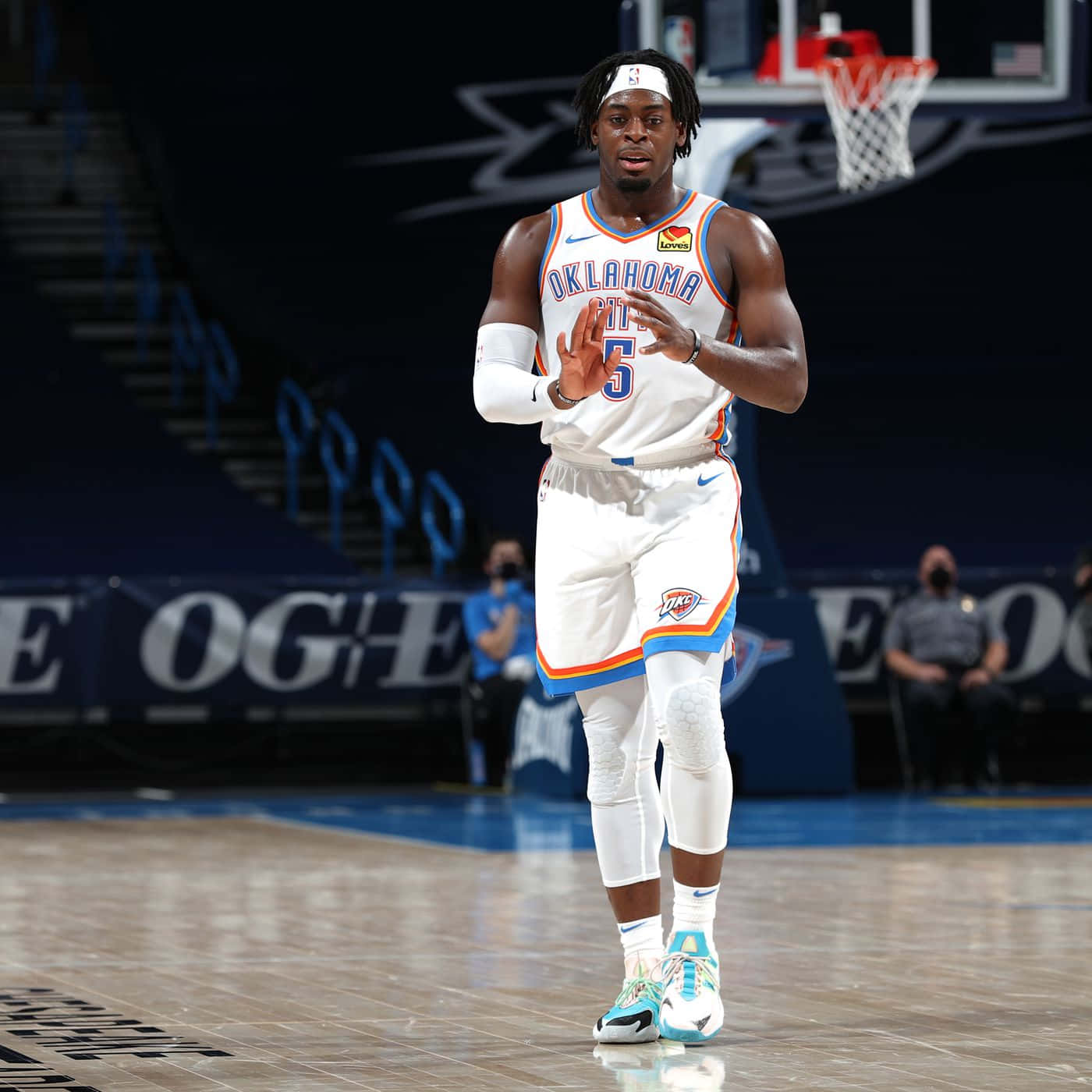 NBA 俄克拉荷馬城雷霆隊路文頓·多特 壁紙 — 一名身穿奧克拉荷馬城球衣的籃球運動員在體育館燈光下的拋光球場上做手勢。