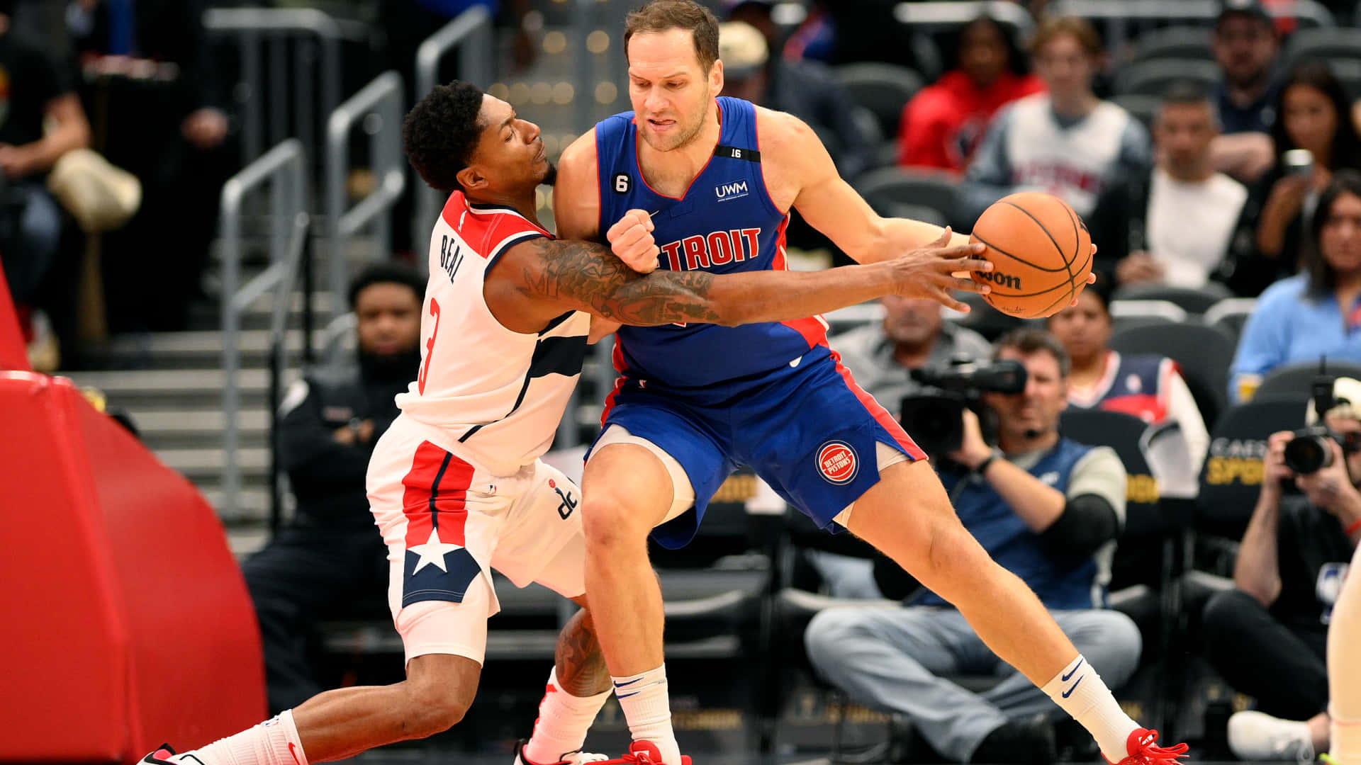 NBA 底特律活塞隊 波揚·博格丹諾維奇 壁紙 — 兩名籃球運動員在職業比賽中激烈爭奪球權，背景有觀眾和攝影機。