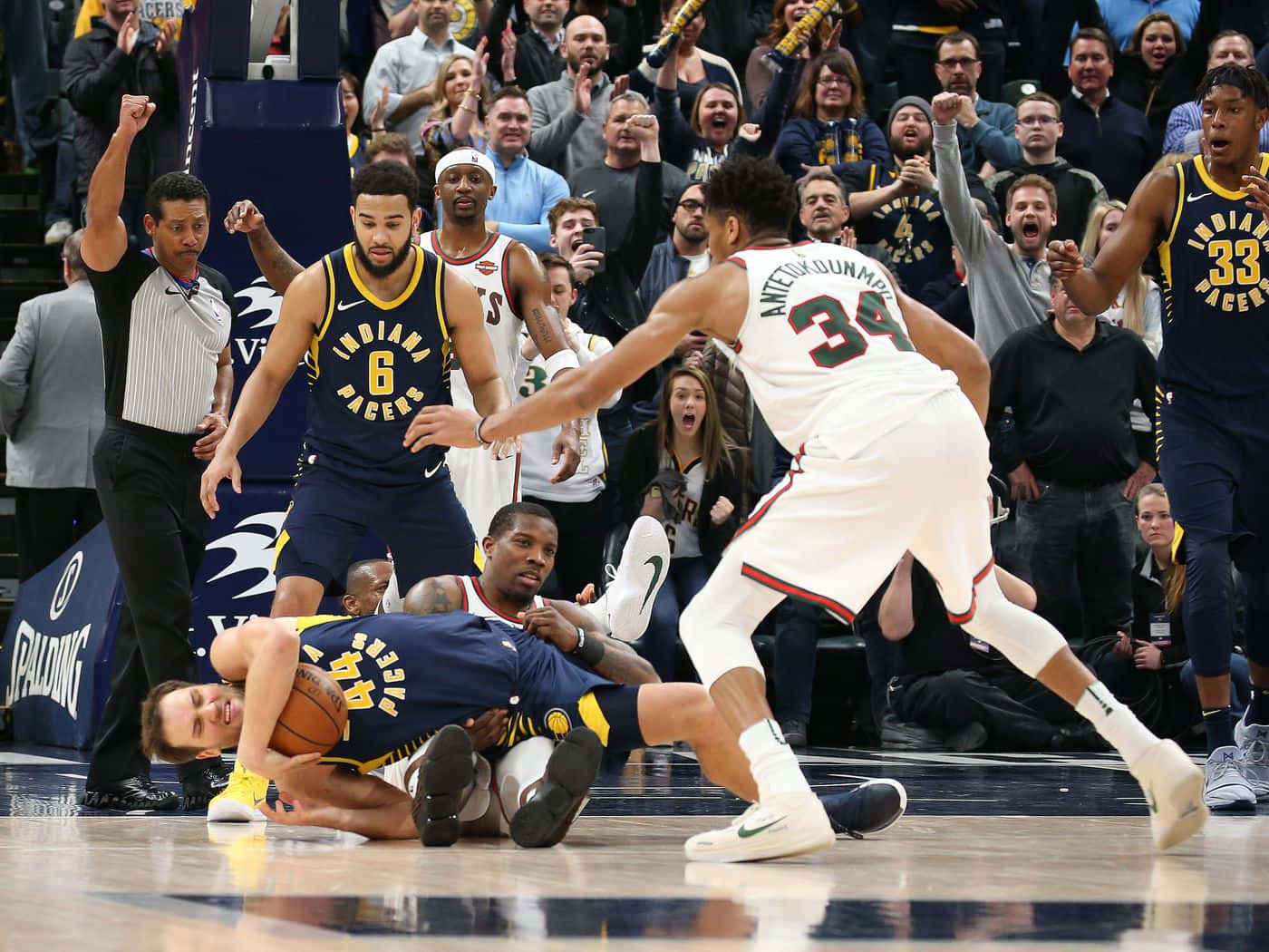 NBA 波揚·博格丹諾維奇 個人犯規 壁紙 — 一名籃球運動員飛身撲向一個鬆脫的球，對手和球迷在比賽中反應激烈。