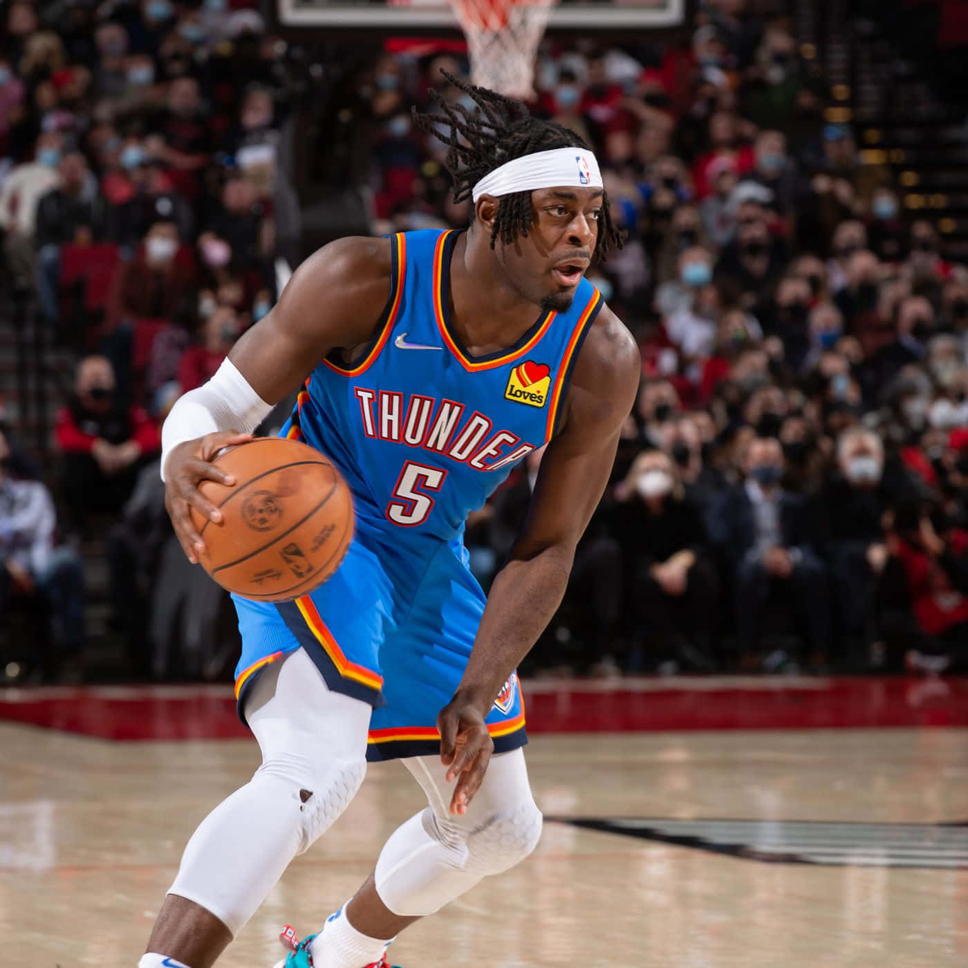NBA 第5號球衣路文頓·多特 壁紙 — 一名身穿藍色雷霆球衣的籃球運動員在比賽中激烈運球，背景是擠滿戴著口罩的人群。