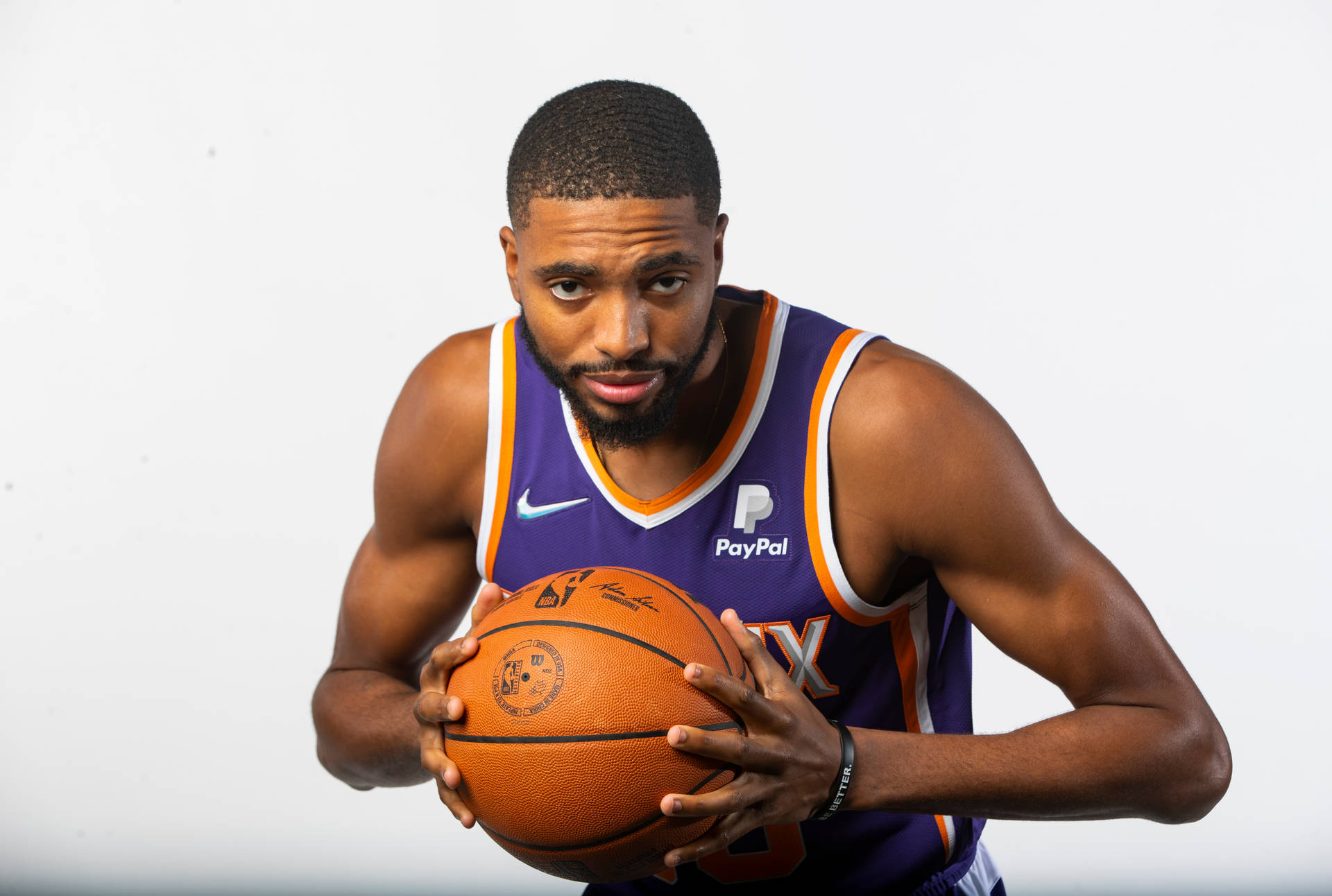 NBA 米卡爾·布里奇斯 快照 壁紙 — 一位專注的籃球運動員穿著紫色球衣，在純白色背景前拿著籃球。
