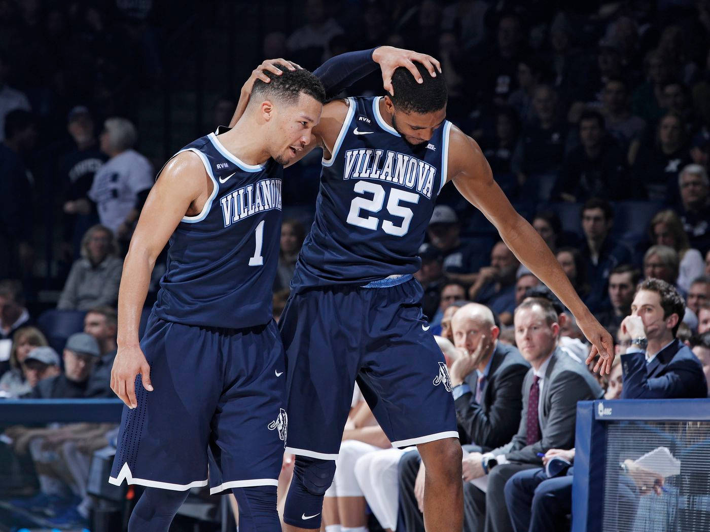 NBA 菲尼克斯太陽隊 米卡爾·布里奇斯 壁紙 — 兩名身穿海軍藍球衣的維拉諾瓦大學籃球運動員在燈光球場上互相搭肩慶祝一次進攻。