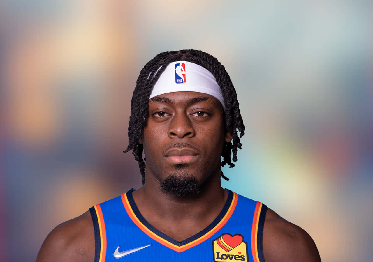 NBA 諾倫·道特 特寫 壁紙 — 一個專注的籃球運動員，身穿藍色球衣，頭戴白色頭帶，在模糊多彩的背景前直視鏡頭。