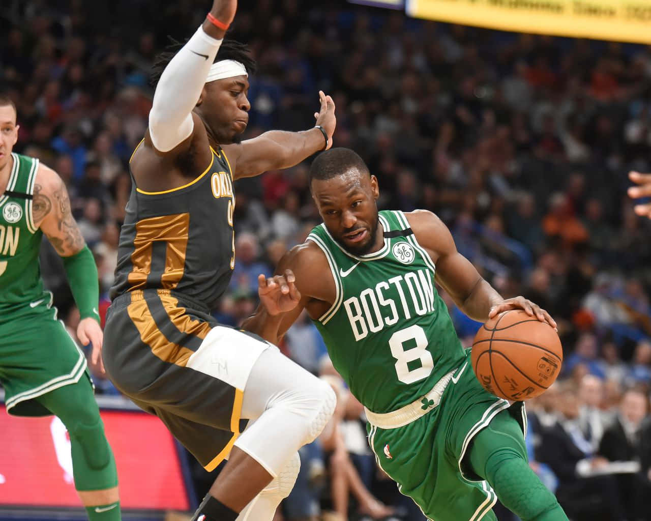 NBA 諾倫·道特 防守對抗肯巴·沃克 壁紙 — 波士頓塞爾特人球員身穿綠色球衣，在激烈的籃球比賽中帶球越過身穿黑金色的防守球員。