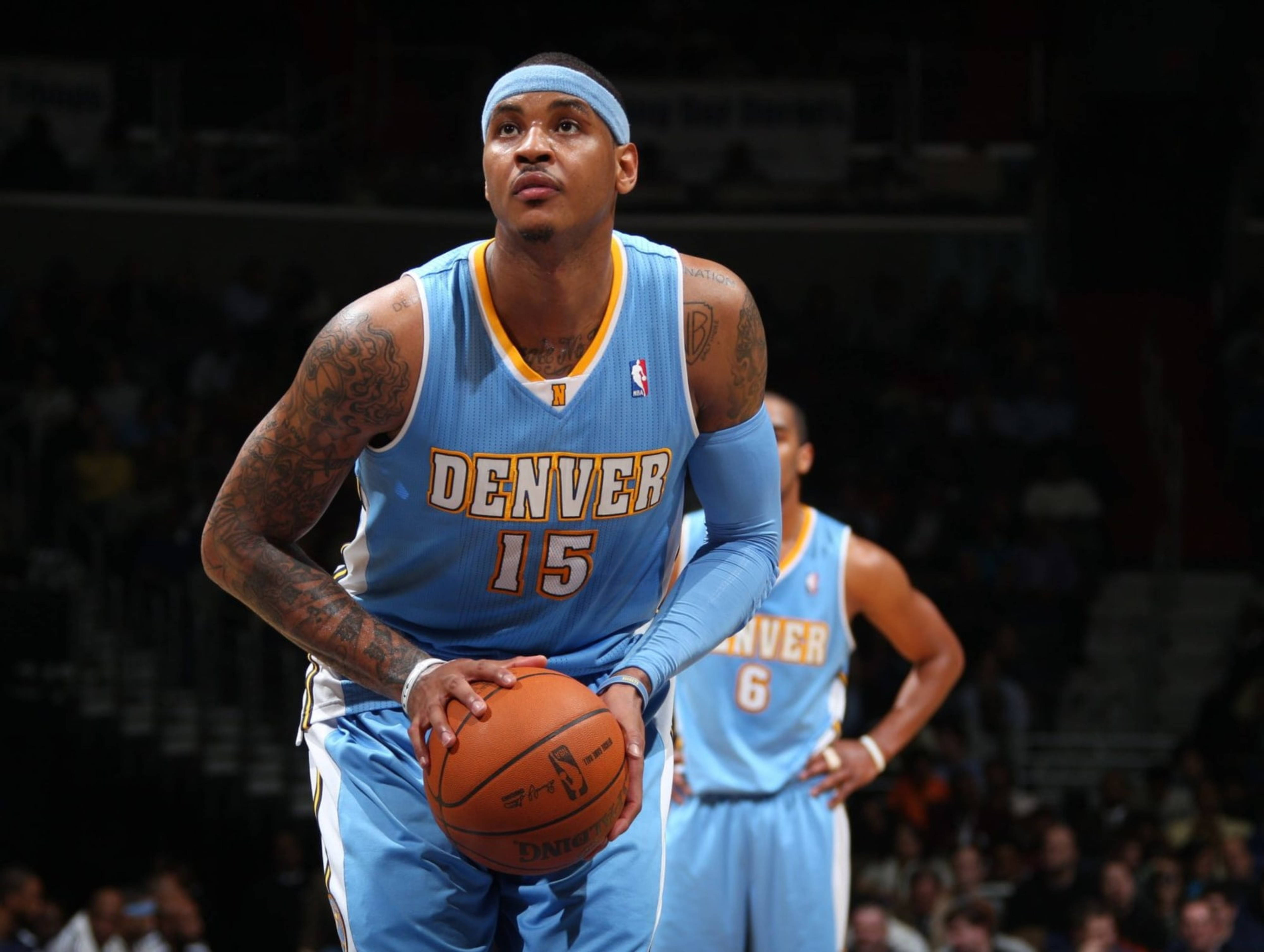 卡梅隆·安東尼NBA丹佛比賽15號 壁紙 — 一位專注的丹佛金塊籃球運動員身穿淺藍色球衣，在場館燈光下於比賽中持球。