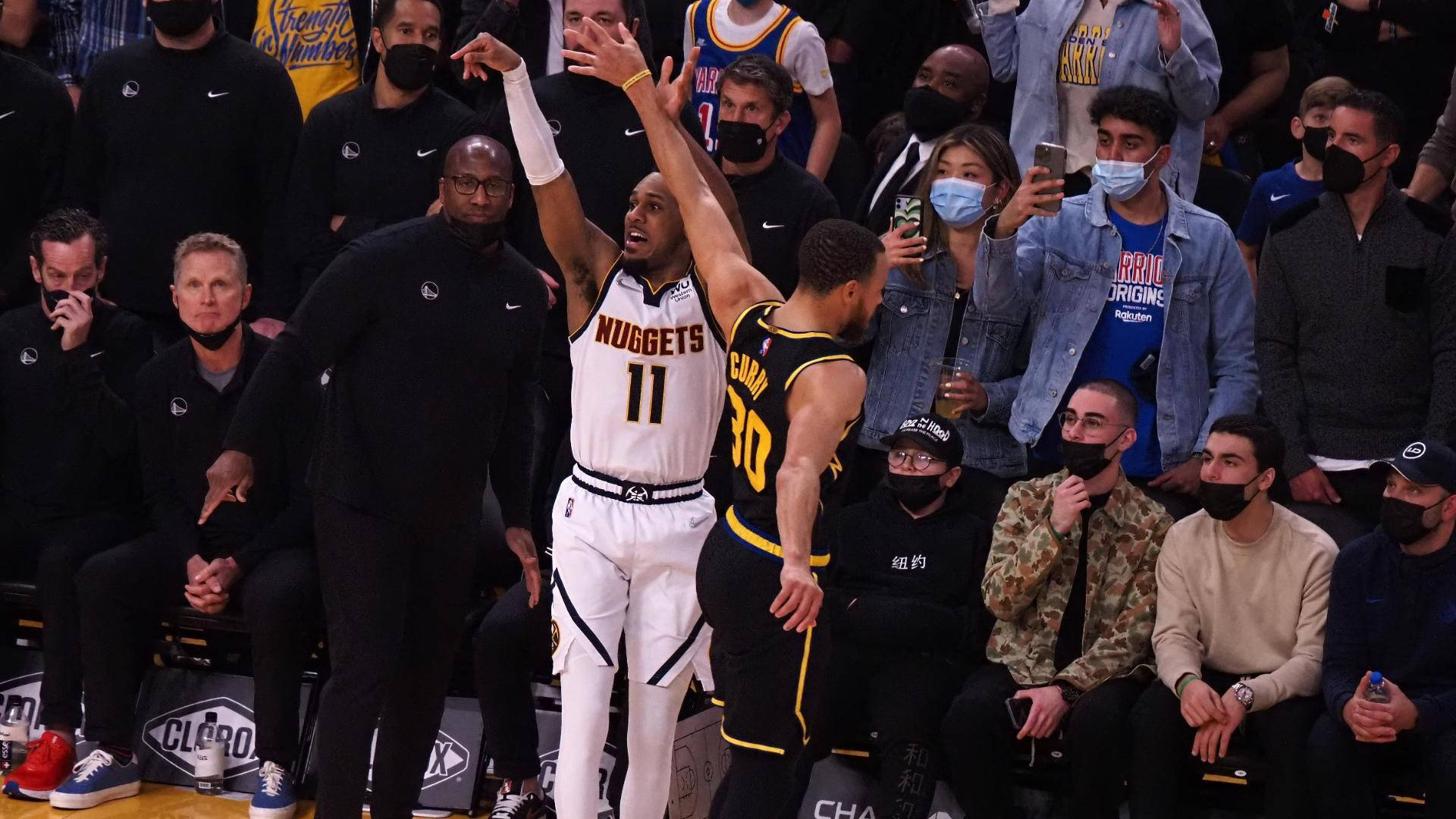 NBA總決賽2021 - 積極進攻的掘金隊 壁紙 — 一名身穿白色金塊球衣、背號11的籃球運動員跳起投籃，同時被一名身穿黑黃色的金州勇士球員防守。