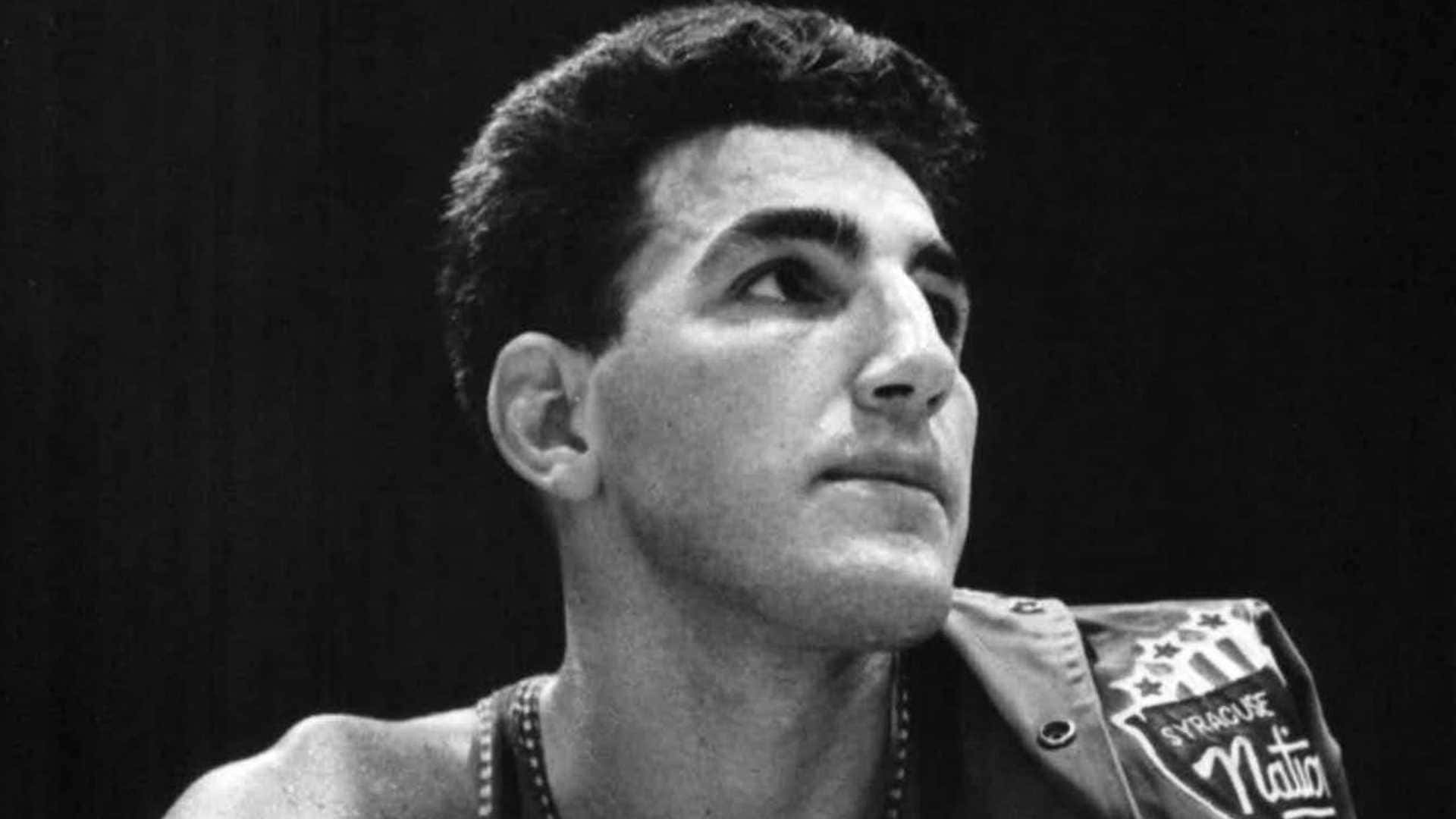 傳奇NBA球員Dolph Schayes比賽瞬間 壁紙 — 一位身穿 Syracuse Nation 外套的年輕籃球運動員的黑白肖像，他正帶著強烈的專注力向上仰望。
