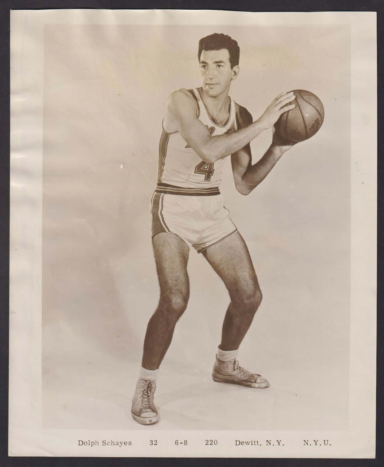 Dolph Schayes身穿N.Y.U.籃球制服，在工作室肖像中持球。