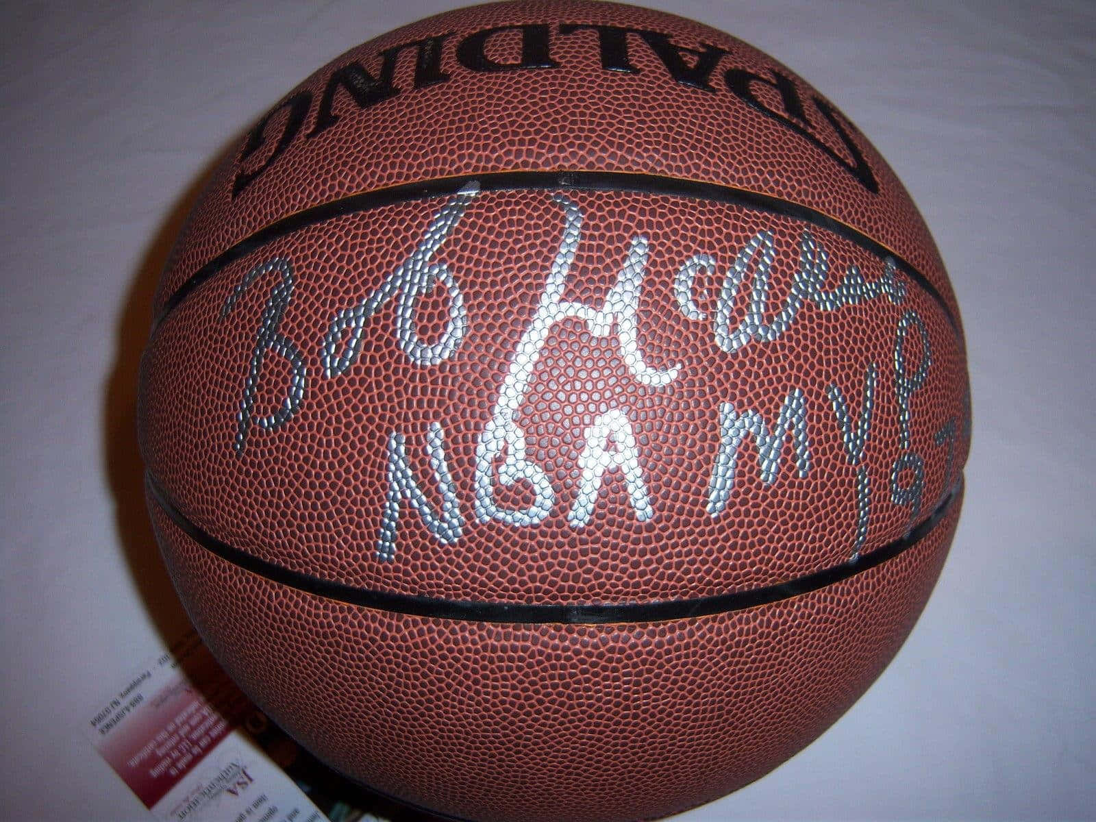 NBA傳奇球星鮑勃·麥卡杜親筆簽名的斯伯丁籃球 壁紙 — 一個棕色籃球的近距離特寫，上面有銀色簽名寫著 Bob Huggins NBA MVP 97。