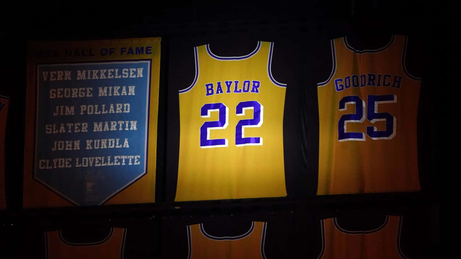 名人堂籃球球衣 Baylor 22 和 Goodrich 25 在黑暗的場館中展示。