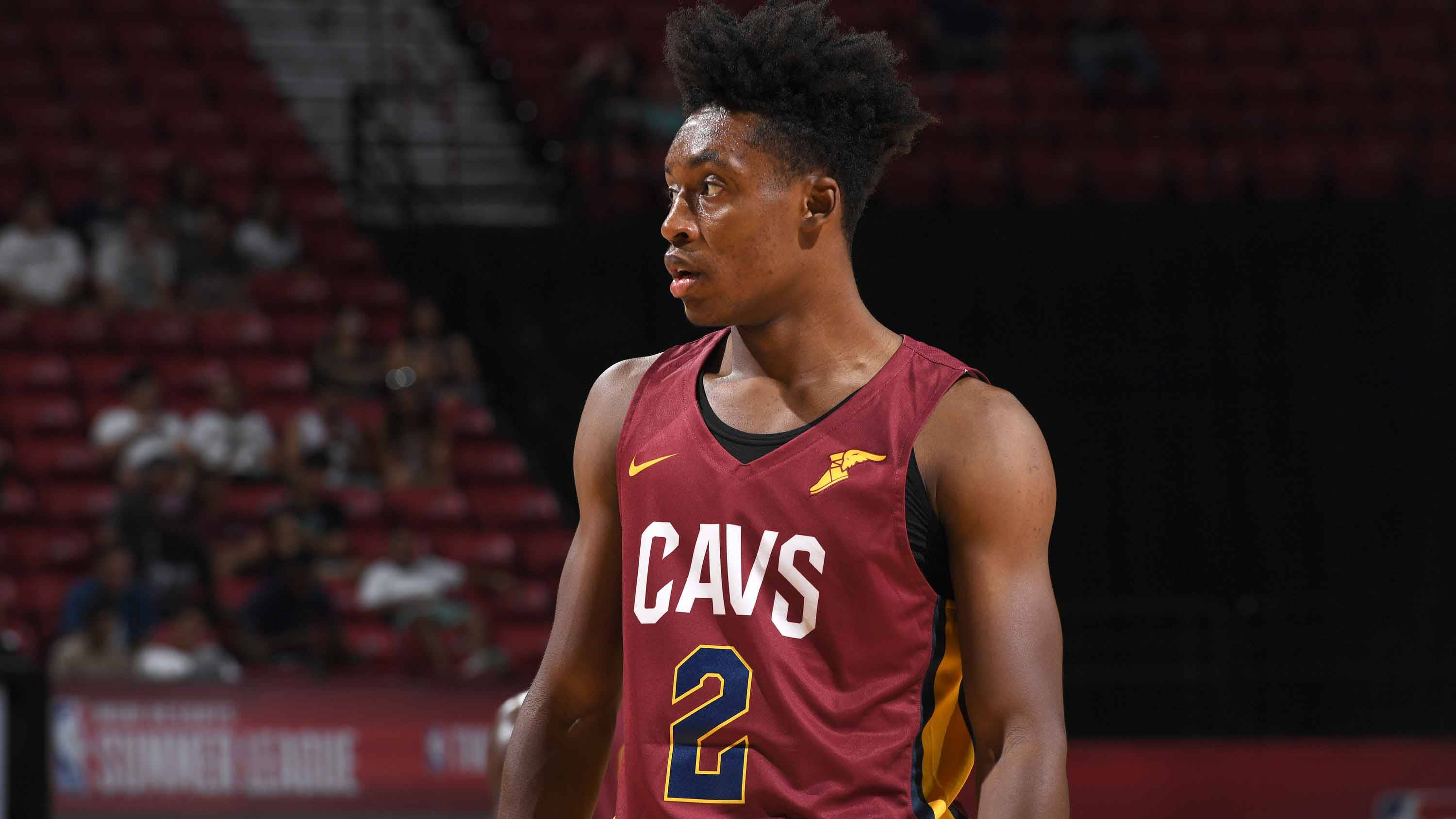 NBA克里夫蘭騎士隊科林·塞克森 壁紙 — 一名專注的籃球運動員身穿棗紅色Cavs球衣，背號二號，站在球場上，場館燈光照射。