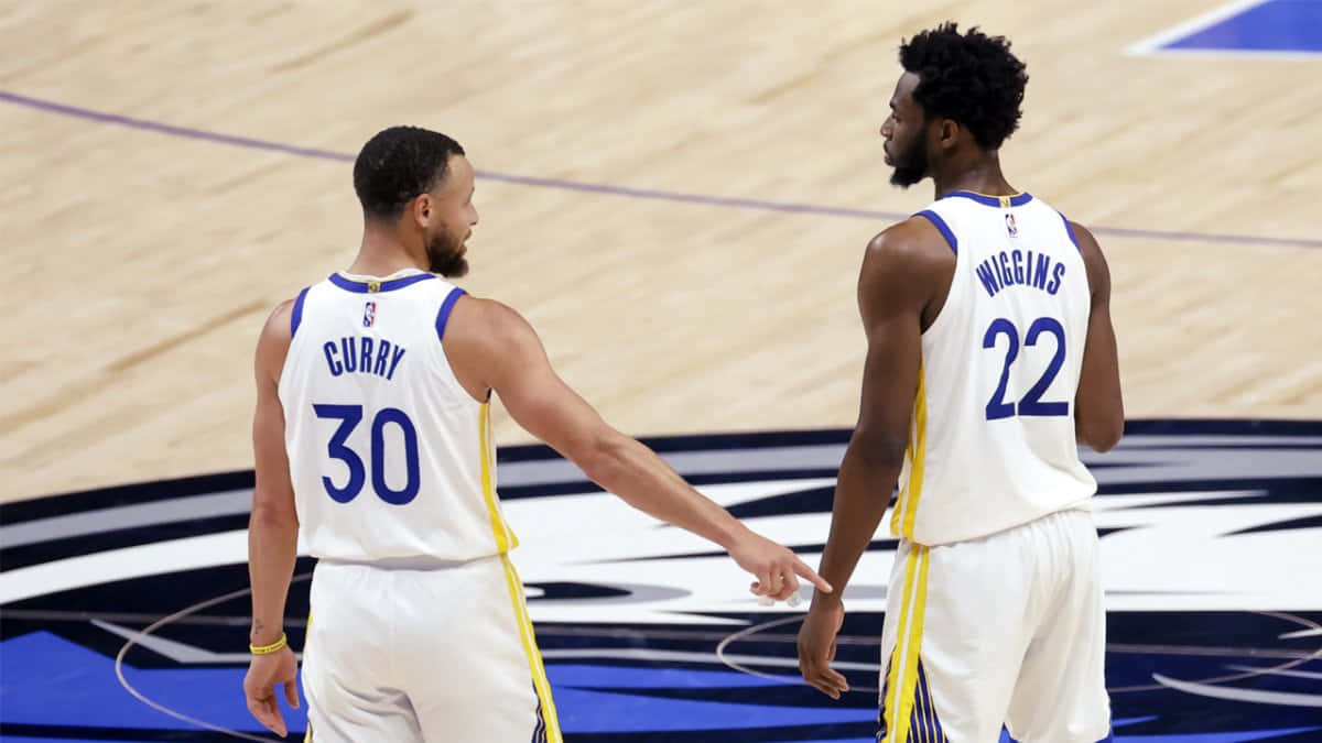 兩名身穿白色球衣的NBA籃球運動員在球場上，一人指向另一人。