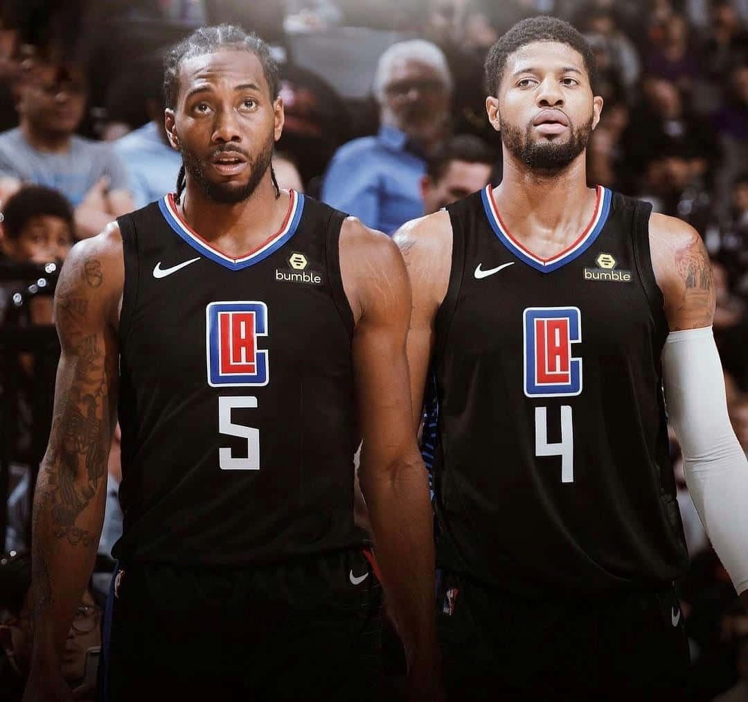 NBA洛杉磯快艇隊球員科懷·倫納德與保羅·喬治照片 壁紙 — 兩名身穿黑色洛杉磯快艇隊球衣的籃球運動員並肩站在球場上，身後是模糊的人群。