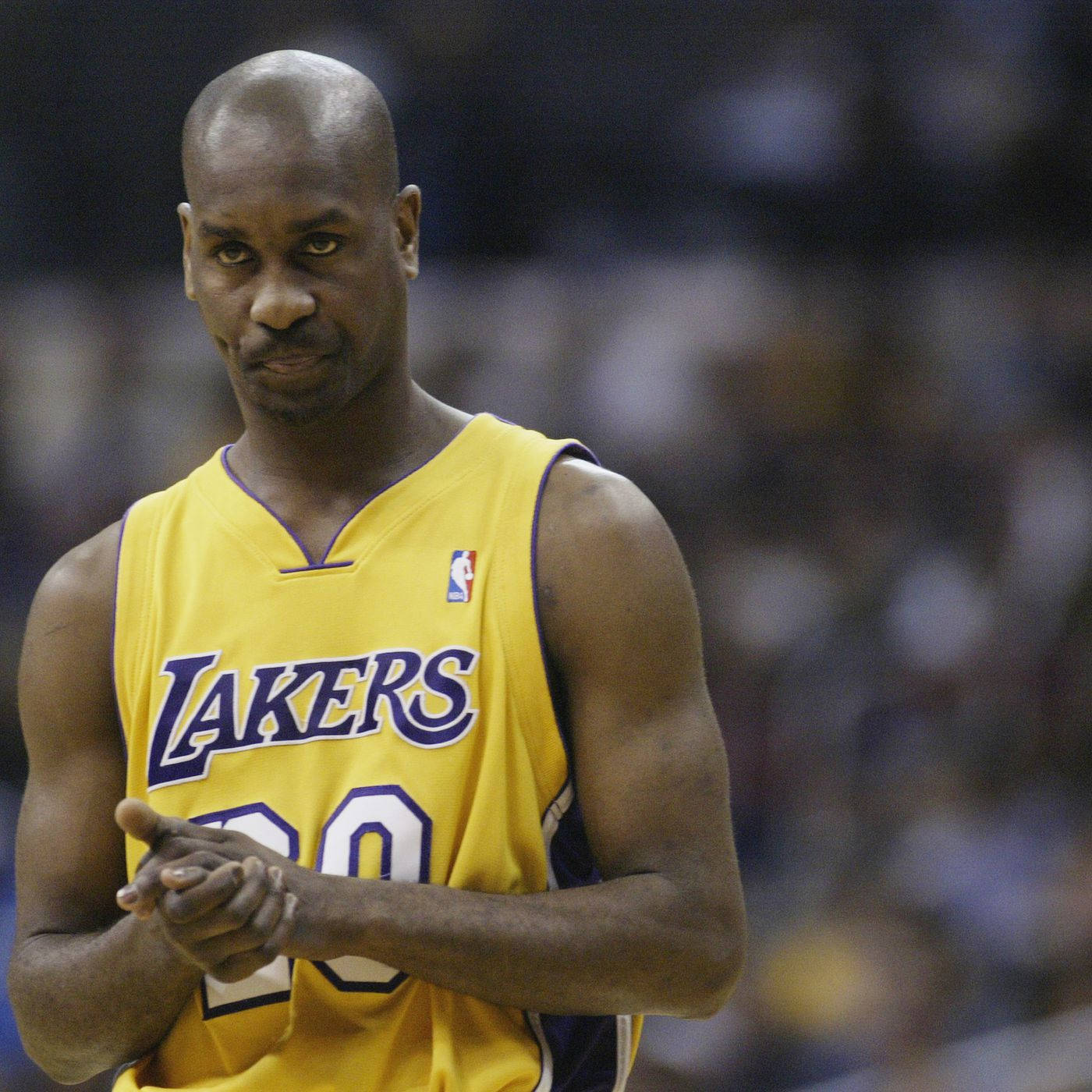 NBA湖人隊加里·德韋恩·佩頓 壁紙 — 一位身穿黃色湖人隊球衣的專注籃球運動員在比賽中拍手，身後是模糊的人群。