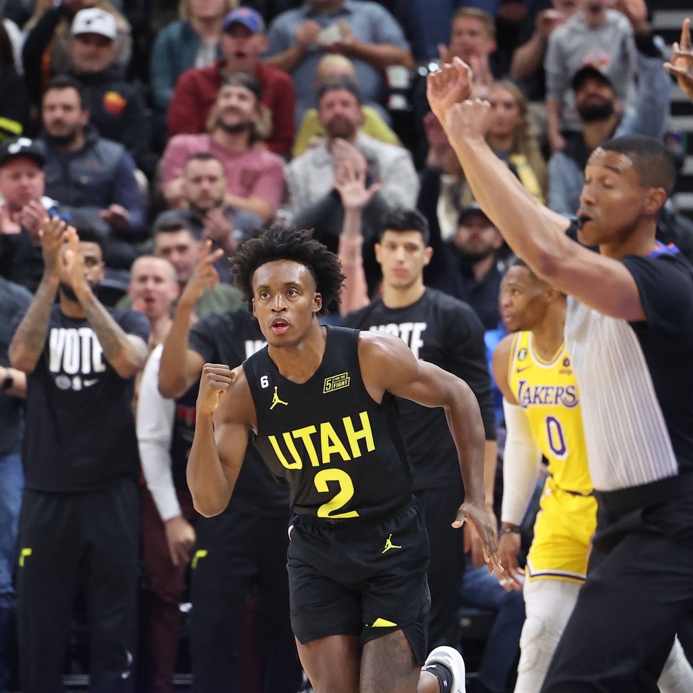 NBA猶他隊科林·塞克森賽場風采 壁紙 — 一位猶他爵士隊籃球運動員身穿黑黃球衣，在觀眾吶喊聲中飛奔越過湖人隊防守球員，進行一場激烈的比賽。