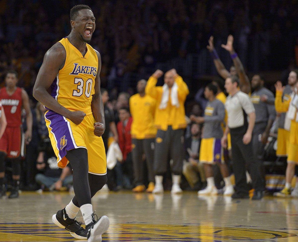 NBA球員 朱利葉斯·蘭德爾 激動人心 壁紙 — 一位身穿黃色湖人隊30號球衣的籃球運動員在光滑的球場上發出勝利的怒吼，隊友和工作人員在他身後慶祝。