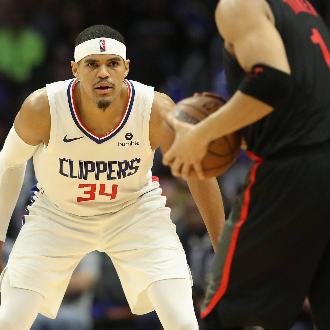 NBA球員托拜厄斯·哈里斯 洛杉磯快艇隊 力量前鋒 壁紙 — 一位專注的快艇籃球運動員，身穿白色34號球衣，在激烈的比賽中防守對手。