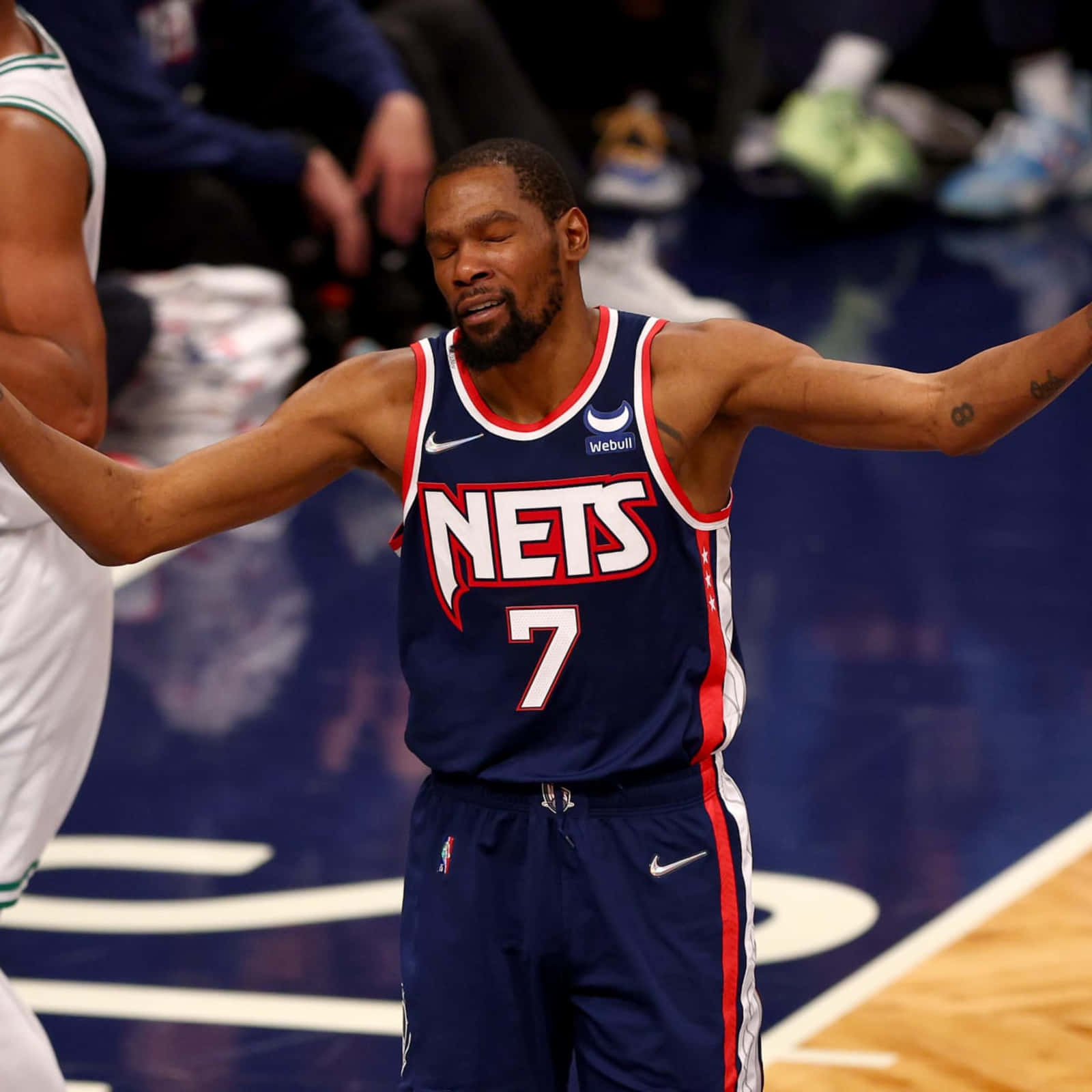 NBA球員搞笑失敗表情照 壁紙 — 籃球運動員凱文·杜蘭特身穿籃網隊球衣，在硬木球場上張開雙臂慶祝。
