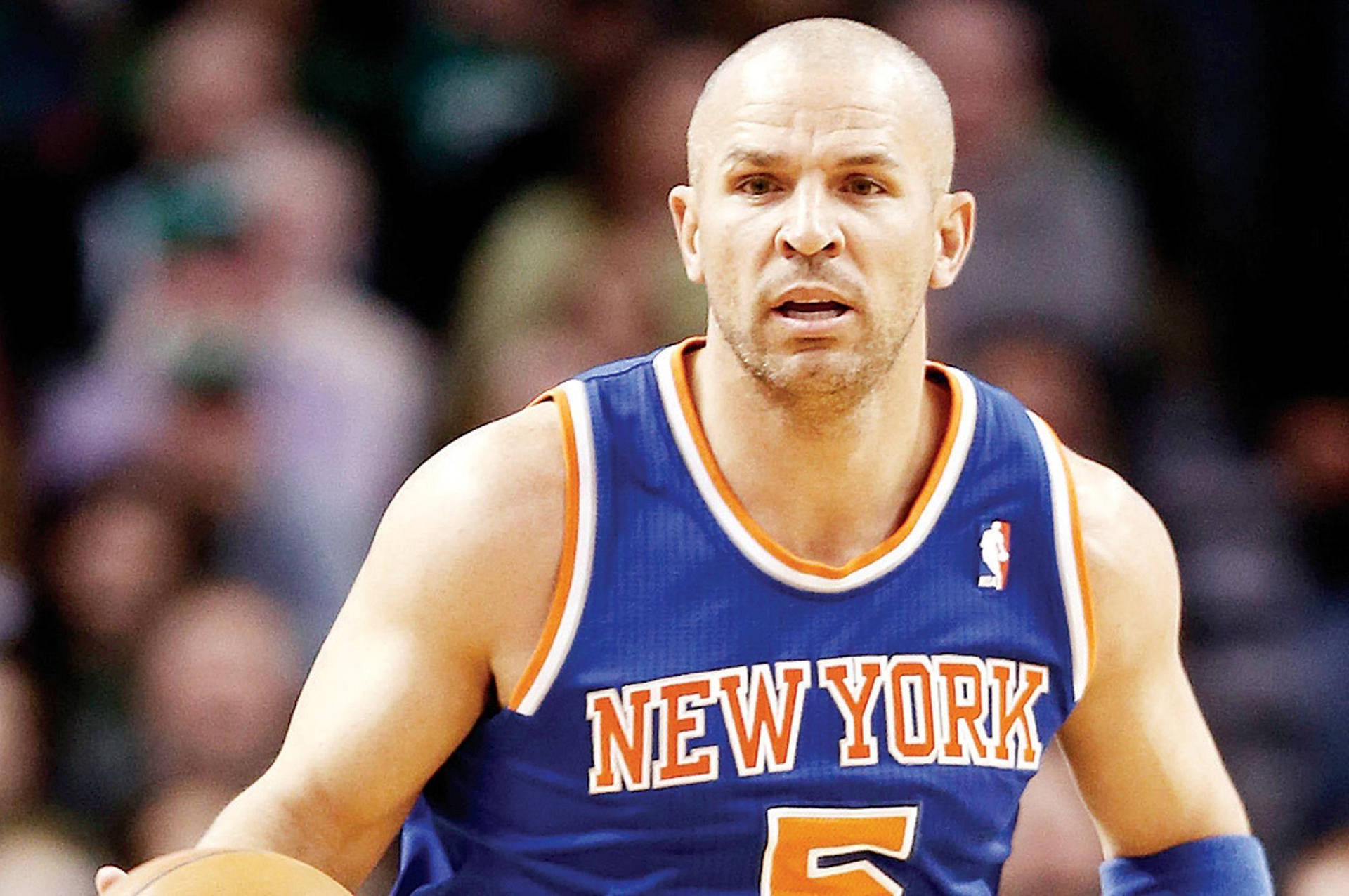 NBA球員賈森·基德驚訝表情 壁紙 — 一位專注的籃球運動員身穿藍色紐約球衣，號碼5，在明亮的場館燈光下於激烈的比賽中運球。