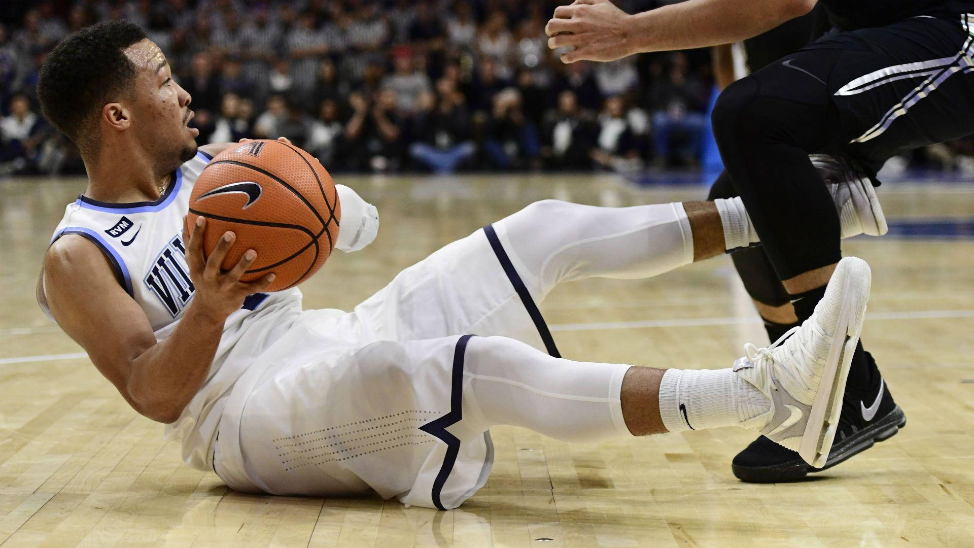 NBA球星Jalen Brunson 壁紙 — 一名身穿白色球衣的籃球運動員在硬木地板上滑行，緊握籃球，而對手則在他上方虎視眈眈。