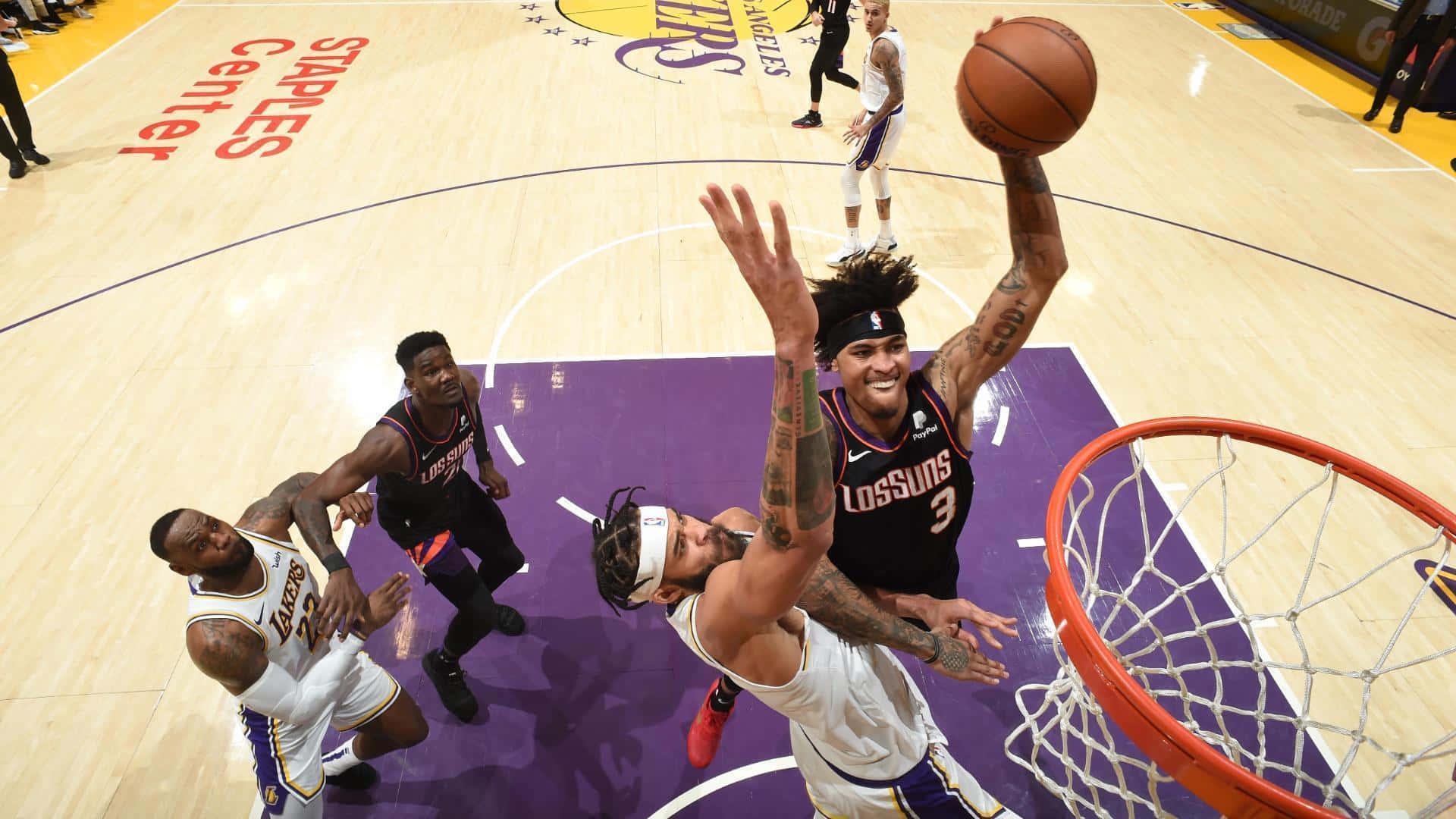 籃球運動員在史台普斯中心隔著防守球員灌籃。