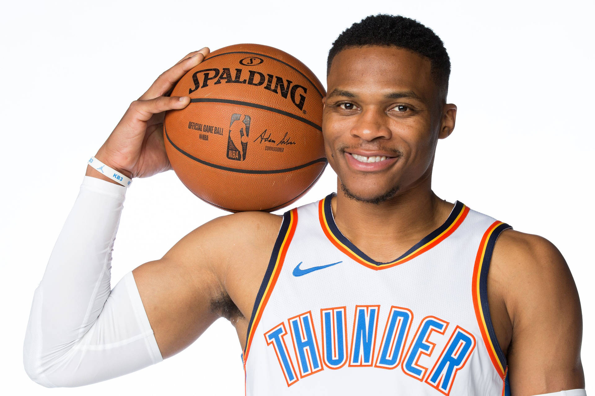 身穿雷霆隊球衣的職業籃球運動員手持 Spalding 籃球。