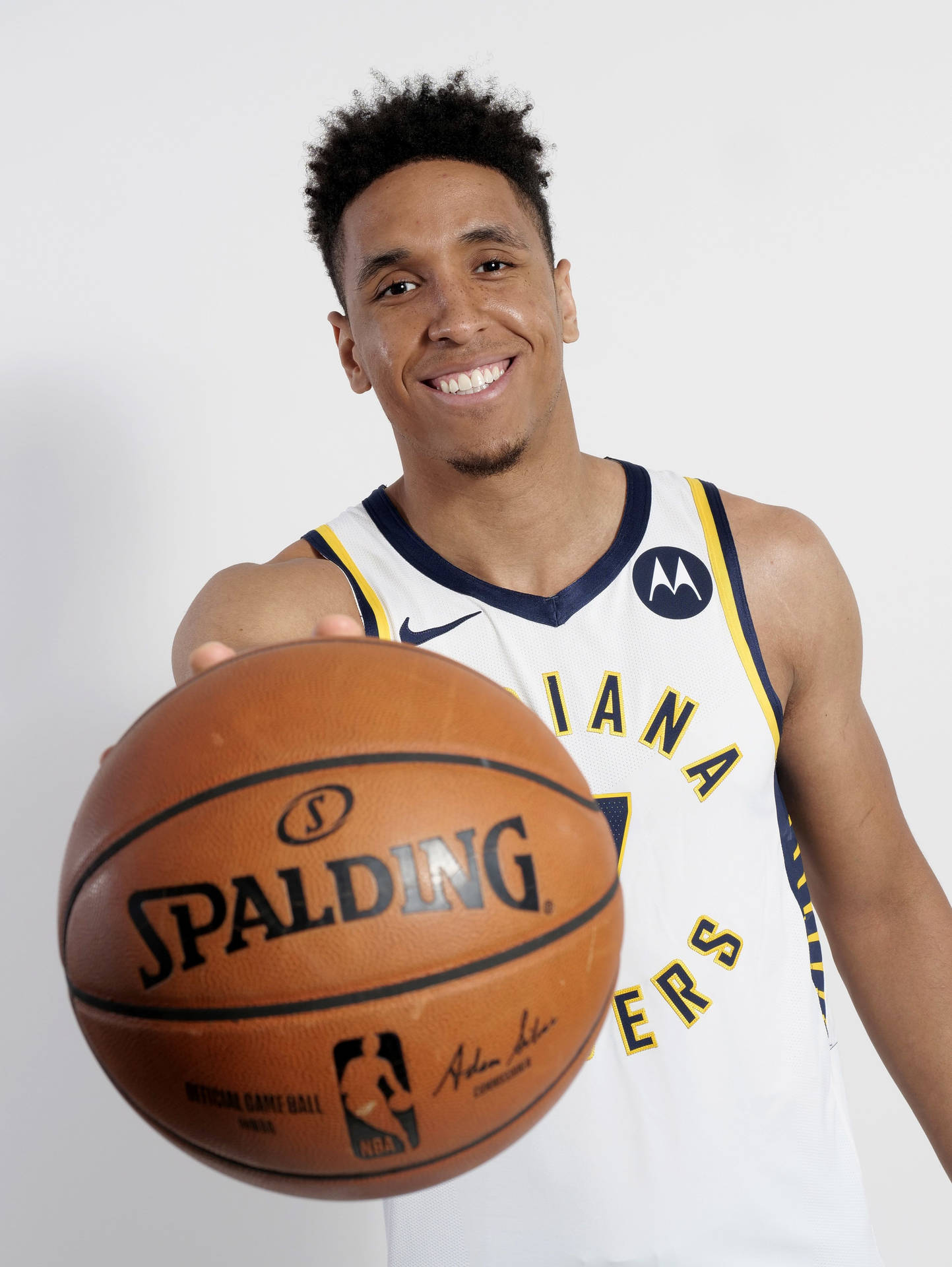 身穿印第安納溜馬隊球衣的籃球運動員手持 Spalding 籃球。