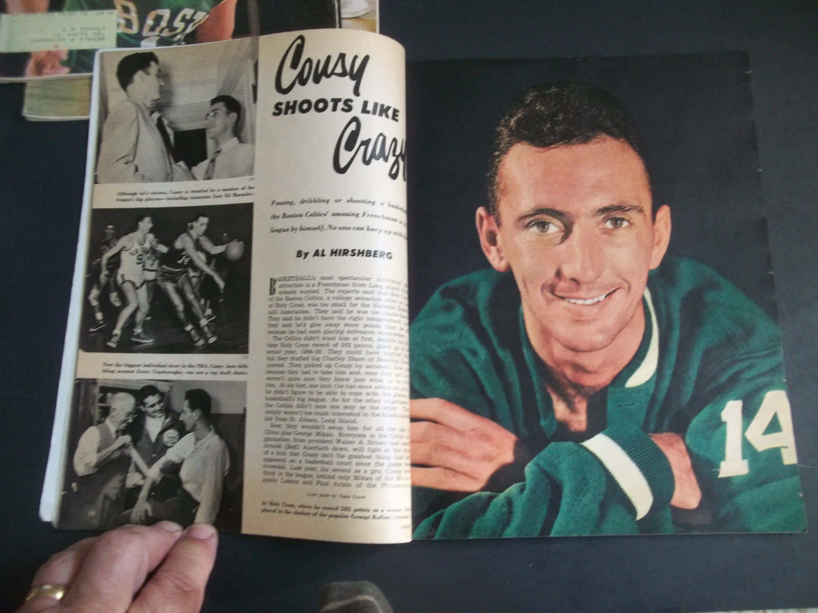 NBA球星鮑勃·庫西雜誌封面 壁紙 — 復古雜誌跨頁，展示一位微笑的籃球運動員，身穿綠色球衣，號碼14，周圍環繞黑白動作照片和文章文字。