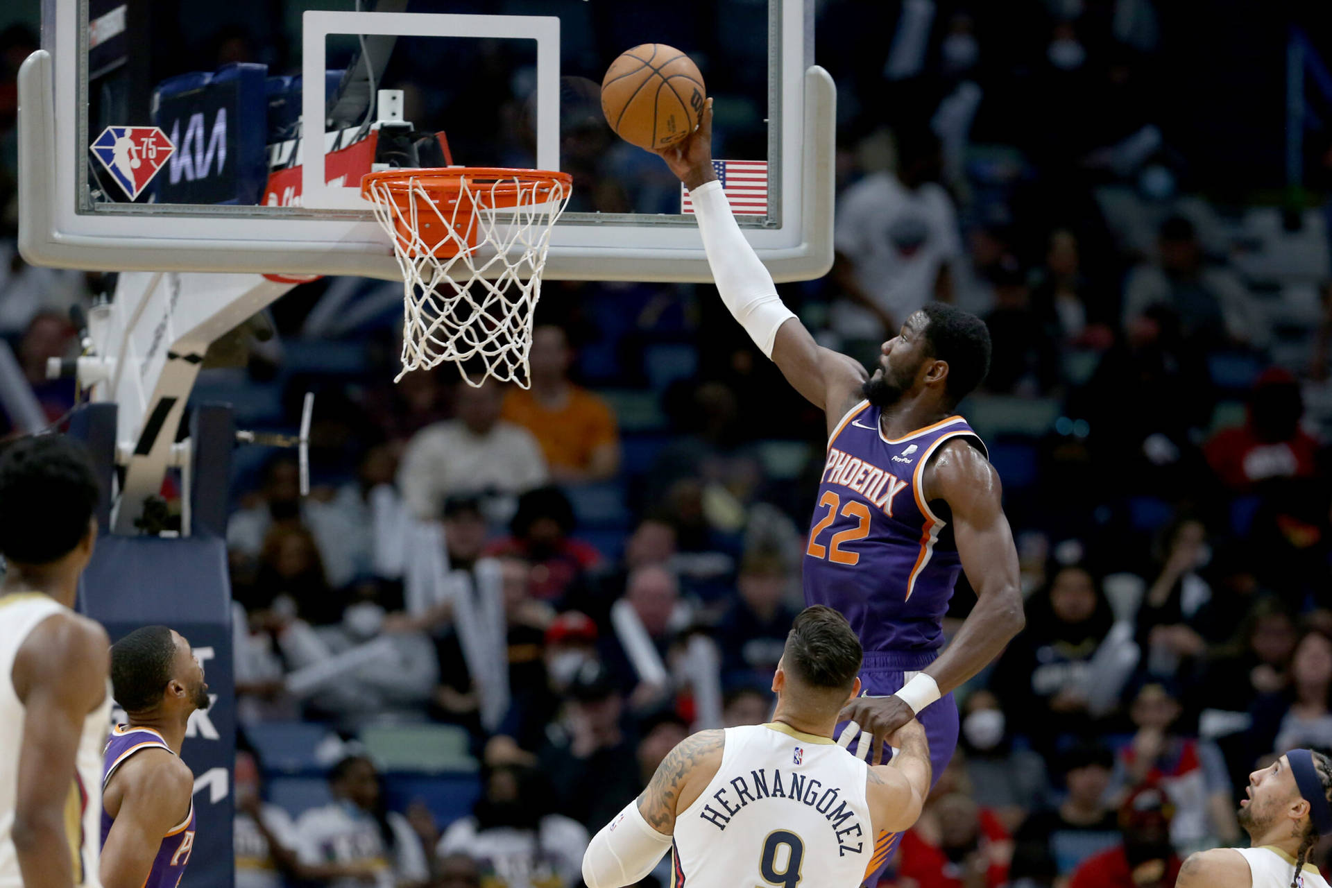 鳳凰城太陽隊球員在NBA比賽中，在防守球員附近灌籃。