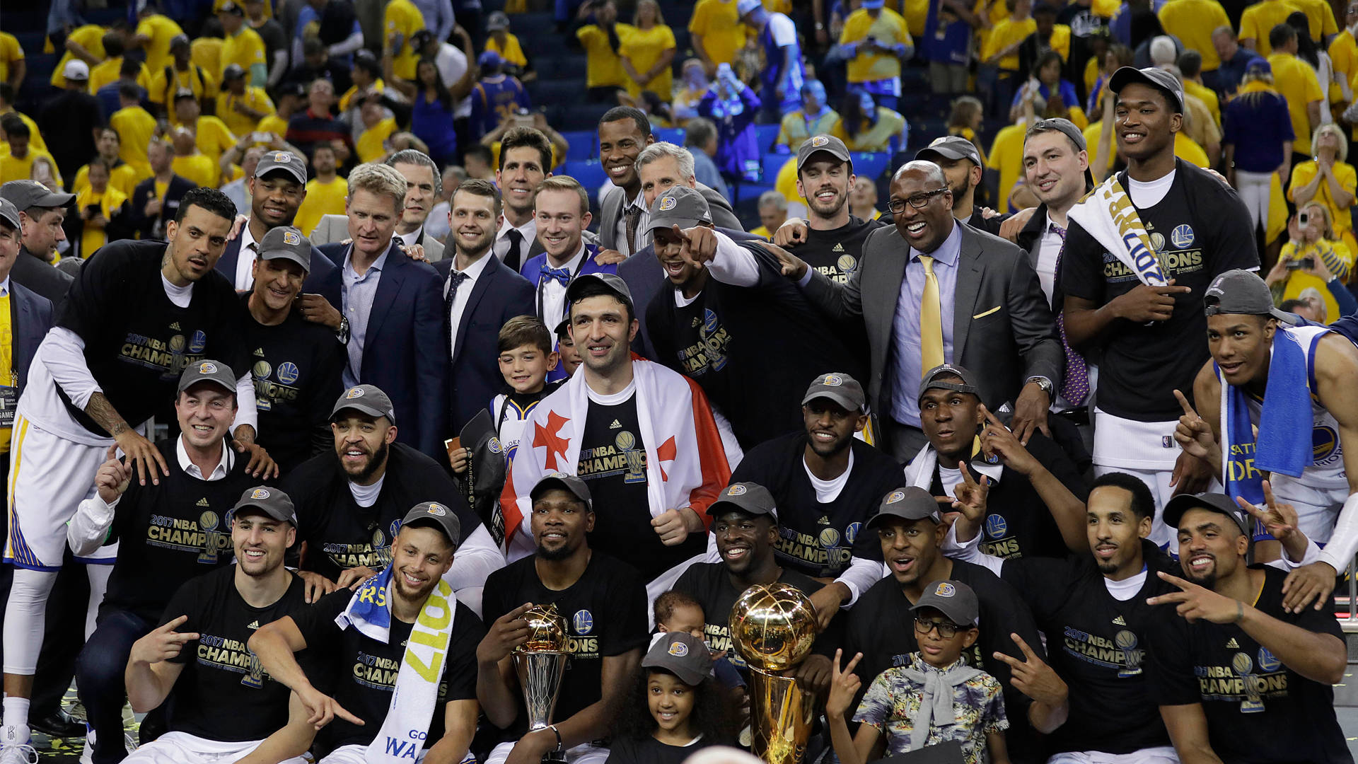 NBA總決賽 2017 金州勇士隊 壁紙 — 金州勇士籃球隊在球場上與獎盃和歡樂的球迷一起慶祝NBA總冠軍勝利。