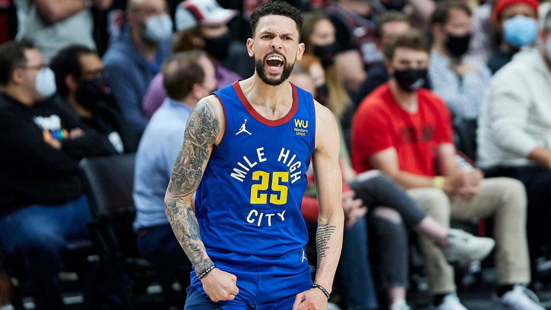 NBA總決賽奧斯汀·里弗斯 壁紙 — 一名身穿藍色 'Mile High City' 球衣的籃球運動員在比賽中激烈咆哮，背景有戴口罩的觀眾。