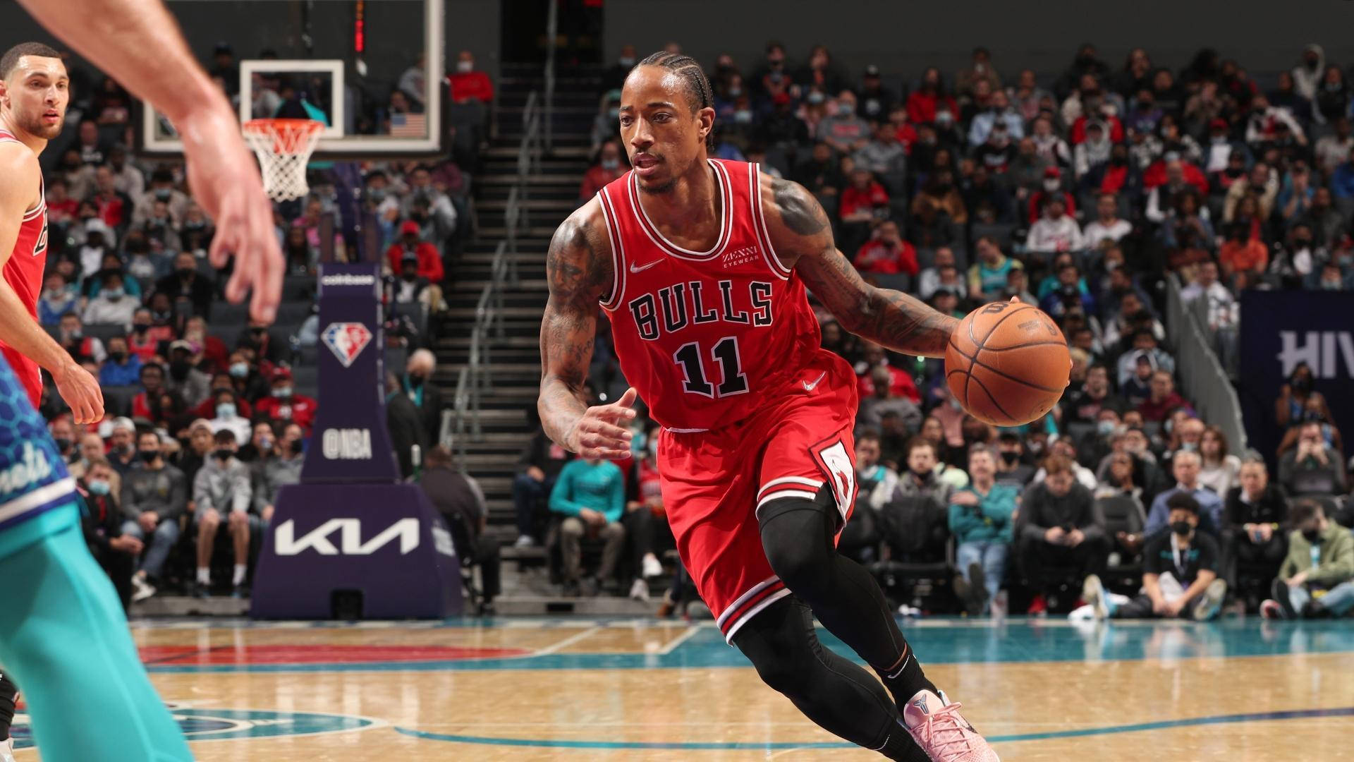 NBA總決賽震撼時刻 壁紙 — 一位身穿紅色球衣的芝加哥公牛隊球員在激烈的NBA比賽中運球，背景是座無虛席的觀眾。