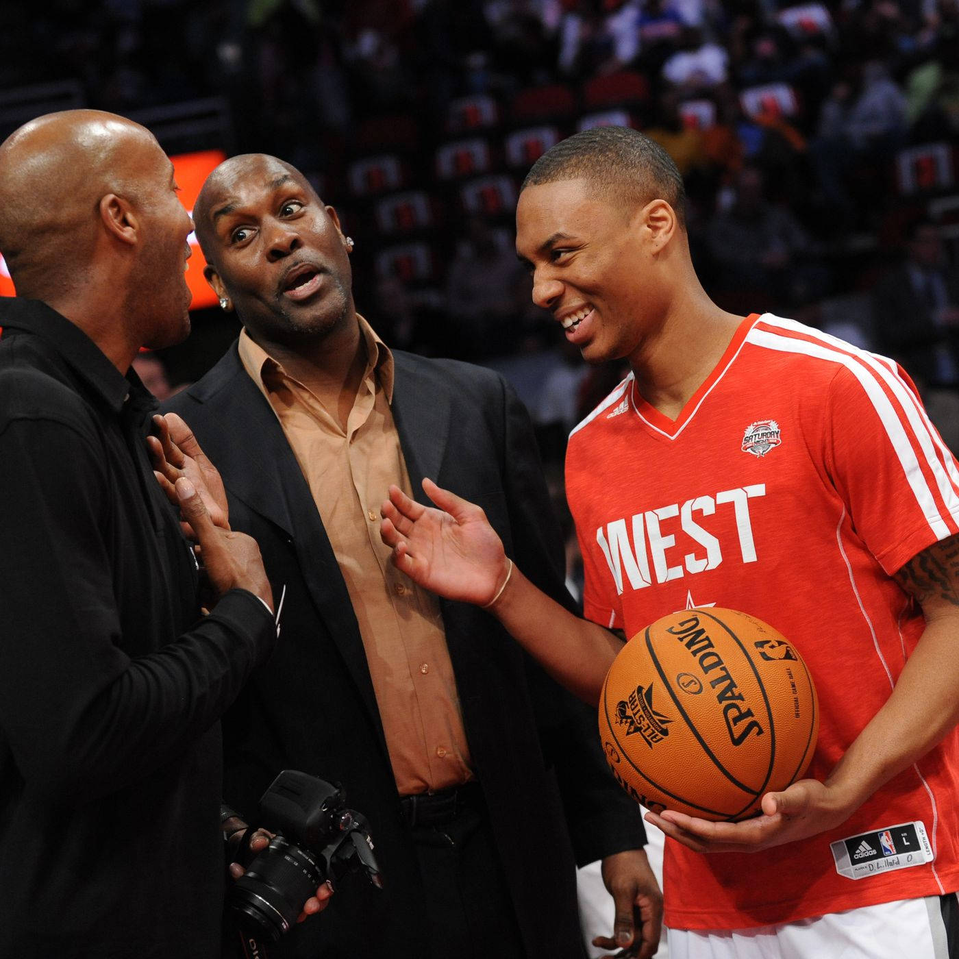 NBA聯盟加里·德溫·佩頓父 壁紙 — 三個男人在籃球場上熱烈交談，其中一人拿著Spalding球。