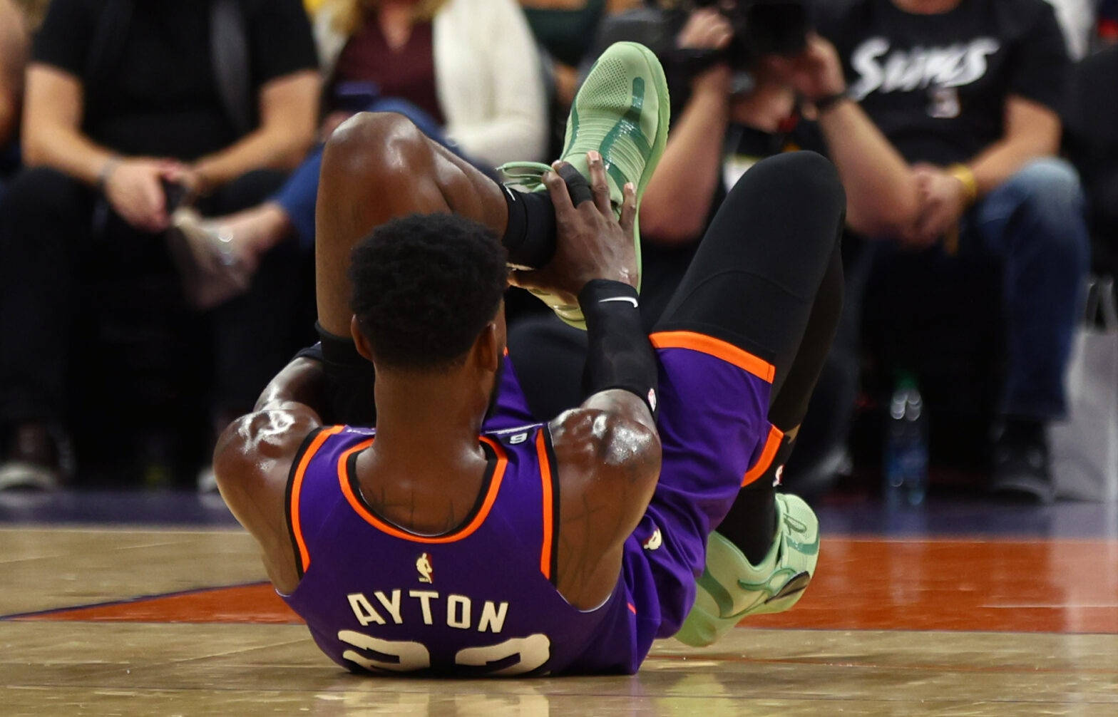 NBA聯賽22號德安德烈·艾頓 壁紙 — 一名身穿紫色球衣的籃球運動員在比賽中坐在球場上，明顯痛苦地抱著腳。