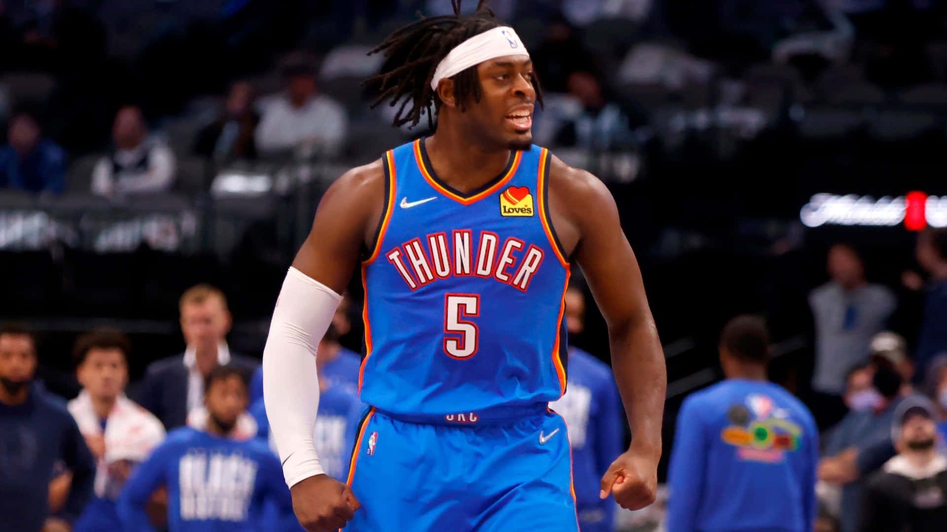 NBA聯賽Luguentz Dort身穿雷霆隊藍色戰袍 壁紙 — 一名身穿藍色雷霆隊5號球衣的籃球運動員在球場上奔跑，背景有觀眾。